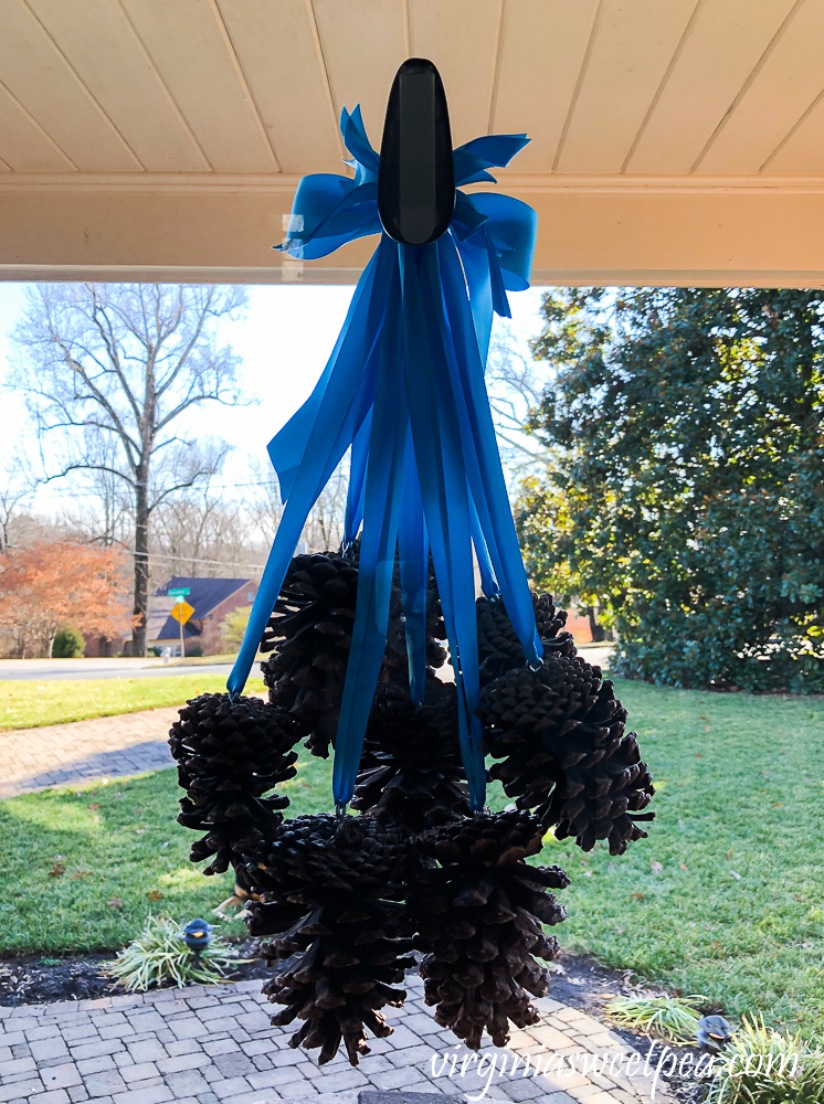 Pine cones hanging from ribbons used for a winter front door decoration