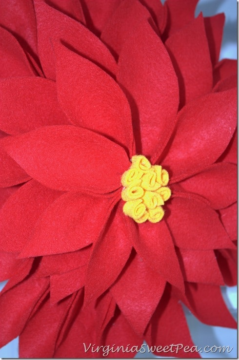  Poinsettia Wreath made using an upcycled Racketball Racket - Get the step-by-step tutorial to make your own Christmas wreath using an old racketball racket.