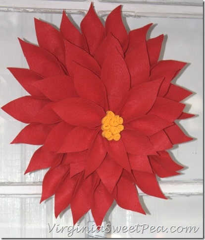  Poinsettia Wreath made using an upcycled Racketball Racket - Get the step-by-step tutorial to make your own Christmas wreath using an old racketball racket.