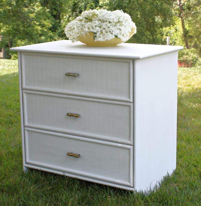 White dresser with wicker look drawers and brass bamboo look pulls.