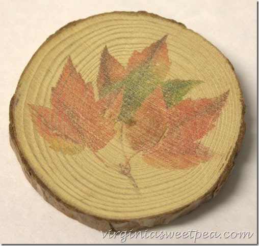 Wood slice made into a coaster with a fall leaf image on it.