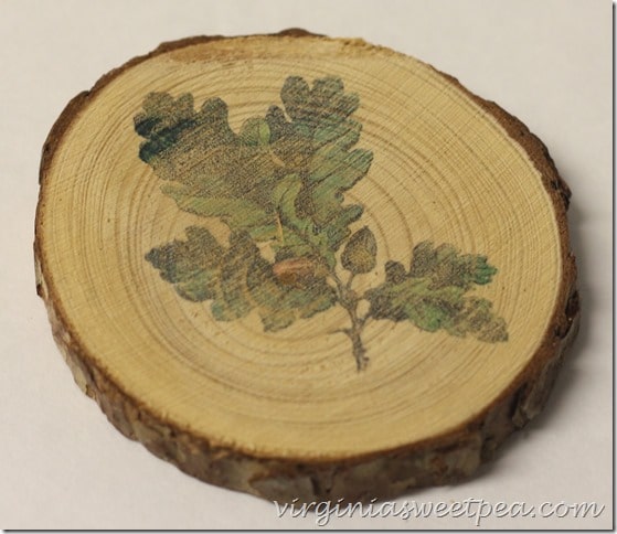 Coaster made from a wood slice with an oak leaf with acorn image on it.