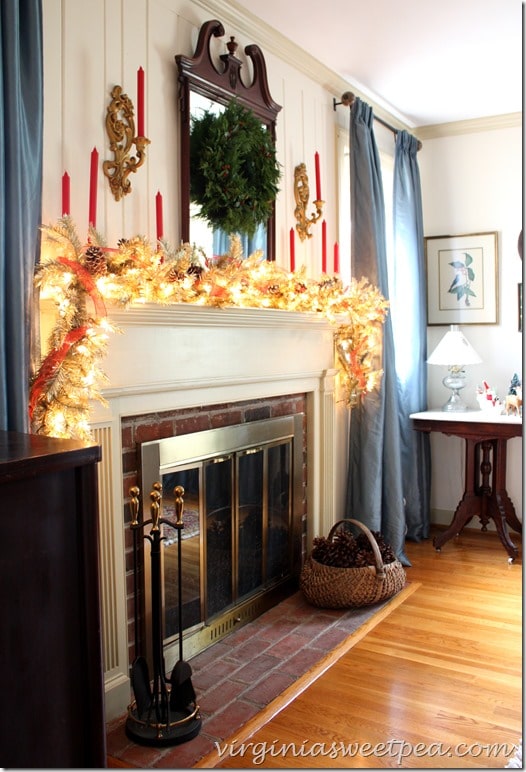 Christmas Mantel for 2015 using lighted garland, snow covered pine cones, and red candles.