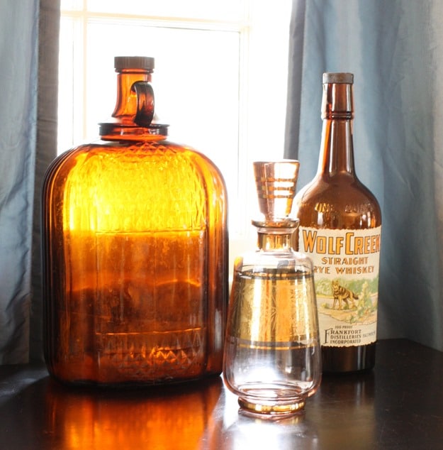 Vintage Brown Clorox Bottle with Wolf Creek Straight Rye Whiskey Bottle and Liquor Decanter I Fall Mantel and Living Room Decor - Get ideas for decorating your mantel and living room for fall. #fall #falldecor #fallvignette #falldecorating #vintage