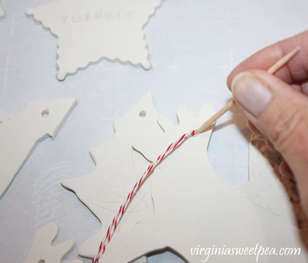 Using a toothpick to add a baker's twine hanger to a clay ornament
