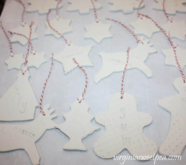 Clay ornaments on a baking sheet with baker's twine hangers