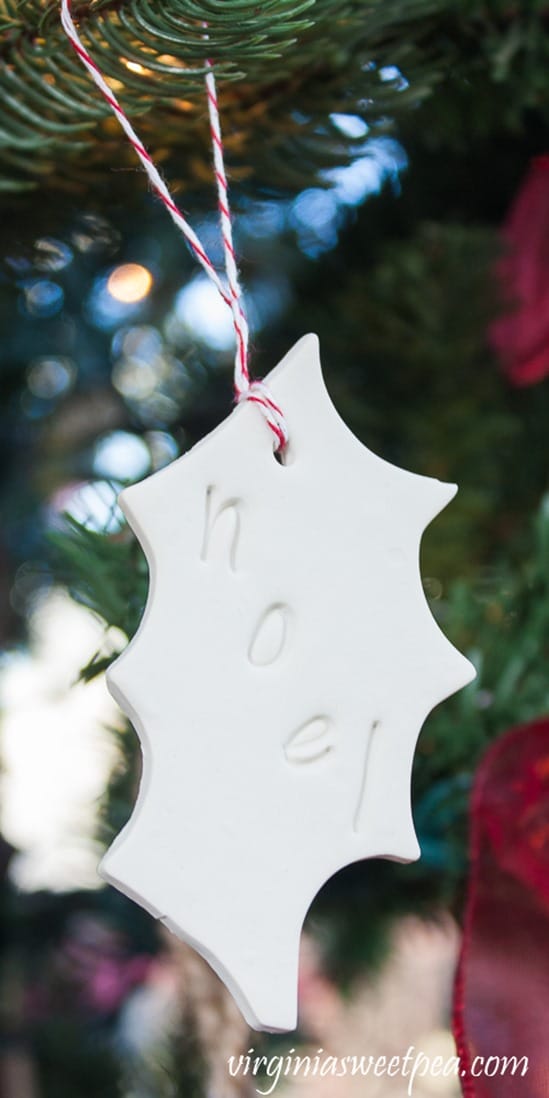 Holly shaped Christmas ornament with noel stamped on it.