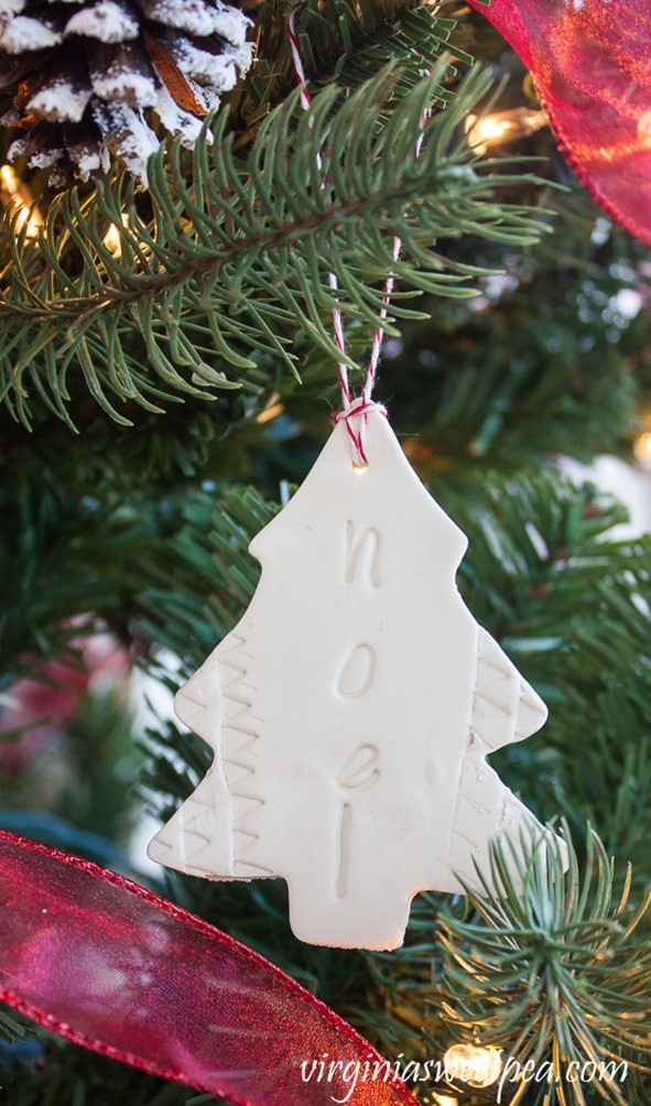 Noel clay Christmas ornament hanging on a tree