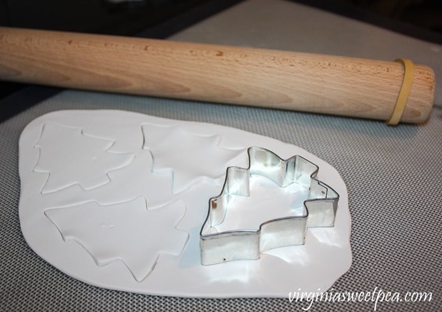 Using a cookie cutter to cut out clay Christmas ornaments