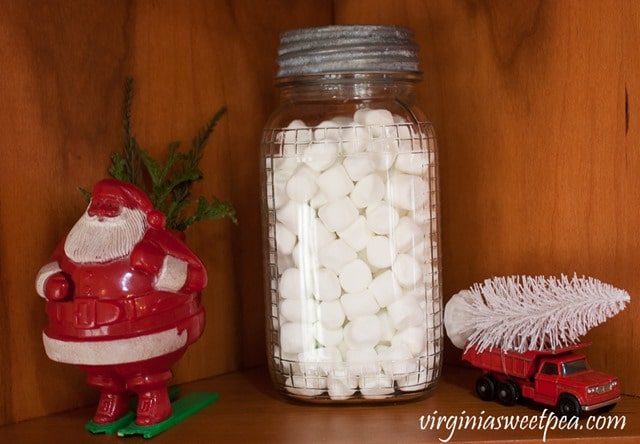 Vintage Christmas Vignette including a Santa Skier Candy Holder, Match Box Truck , and an antique jar filled with marshmallows. - virginiasweetpea.com