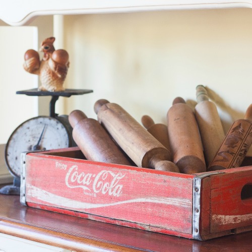 Vintage Coca-Cola Crate filled with Antique Rolling Pins - Part of a farmhouse style display on a kitchen hutch. virginiasweetpea.com