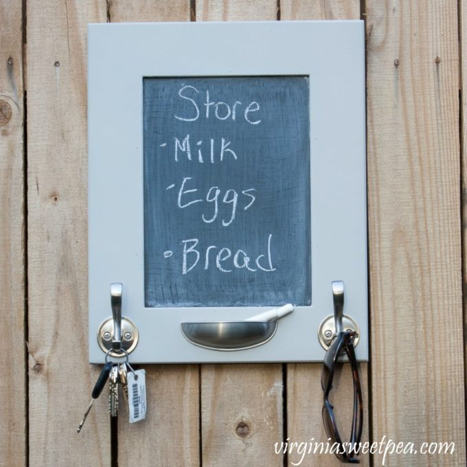 Use a cabinet door to make a message board and organizer. It's a perfect spot to hang your keys and write notes for your family. #upcycle #repurpose #diy #diyproject #upcycleproject
