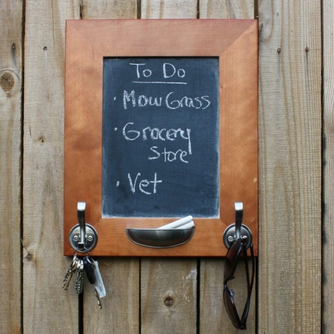 DIY Cabinet Door Message Board and Organizer - A kitchen cabinet door is transformed into a message center with hooks for organization.