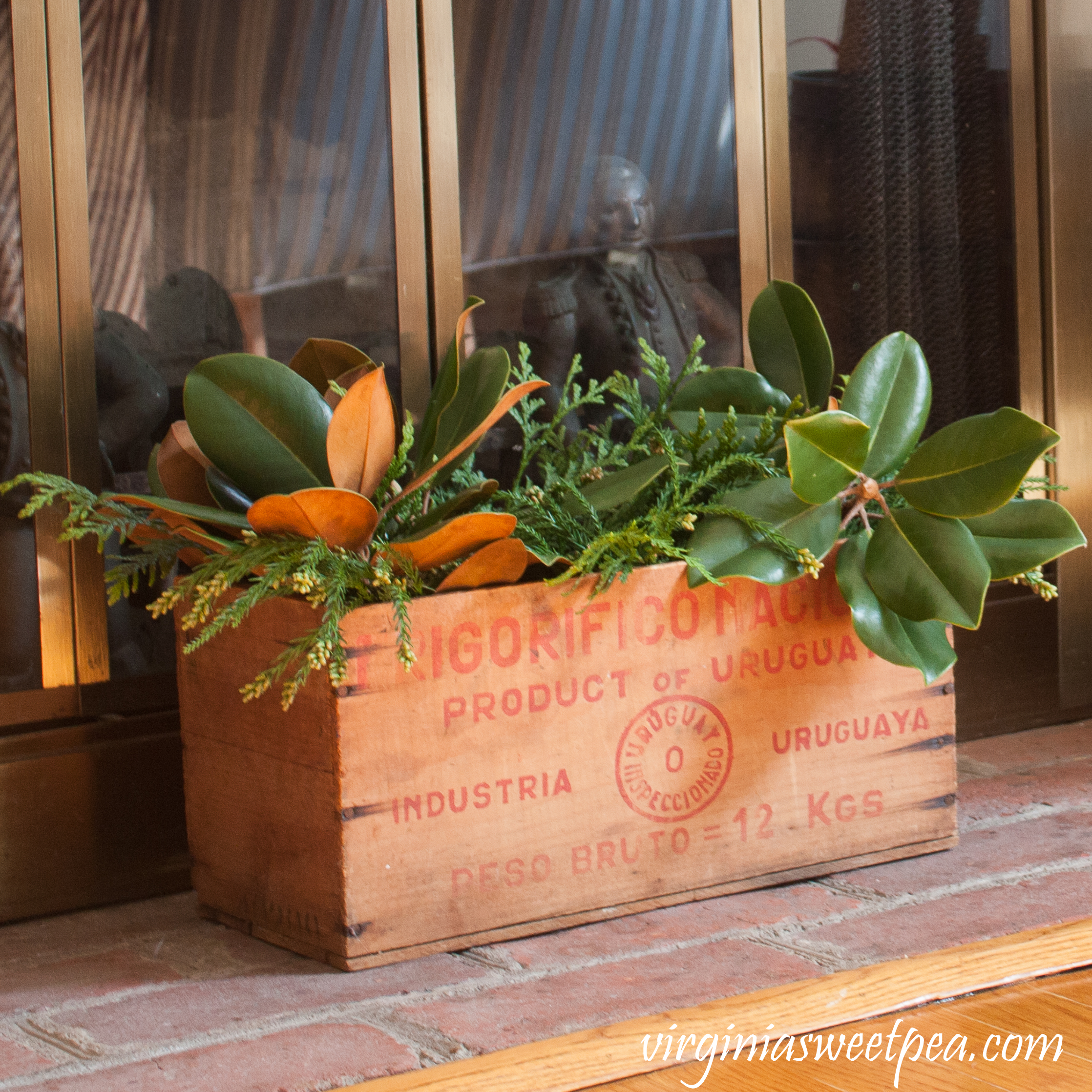 Vintage box filled with greens on the hearth for Christmas #christmas #christmashomedecor #christmasmantel #christmasideas #favoritechristmasideas #vintagechristmas