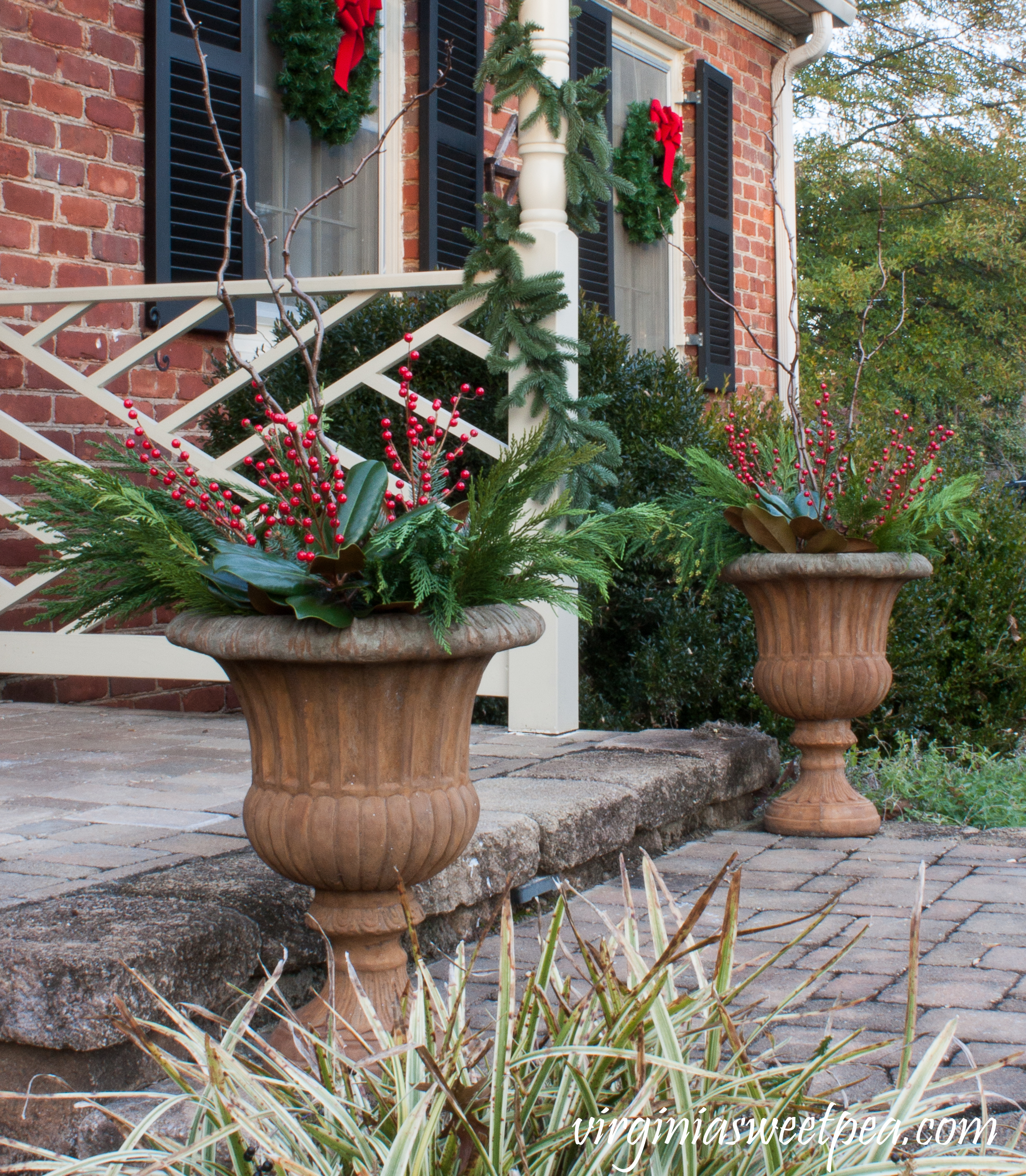 Christmas Front Porch and Holiday Door Decor - Urns filled with greenery, berries, and curly willow for Christmas. #christmas #christmasurns #christmasdoors #christmasoutdoors #christmasdecor