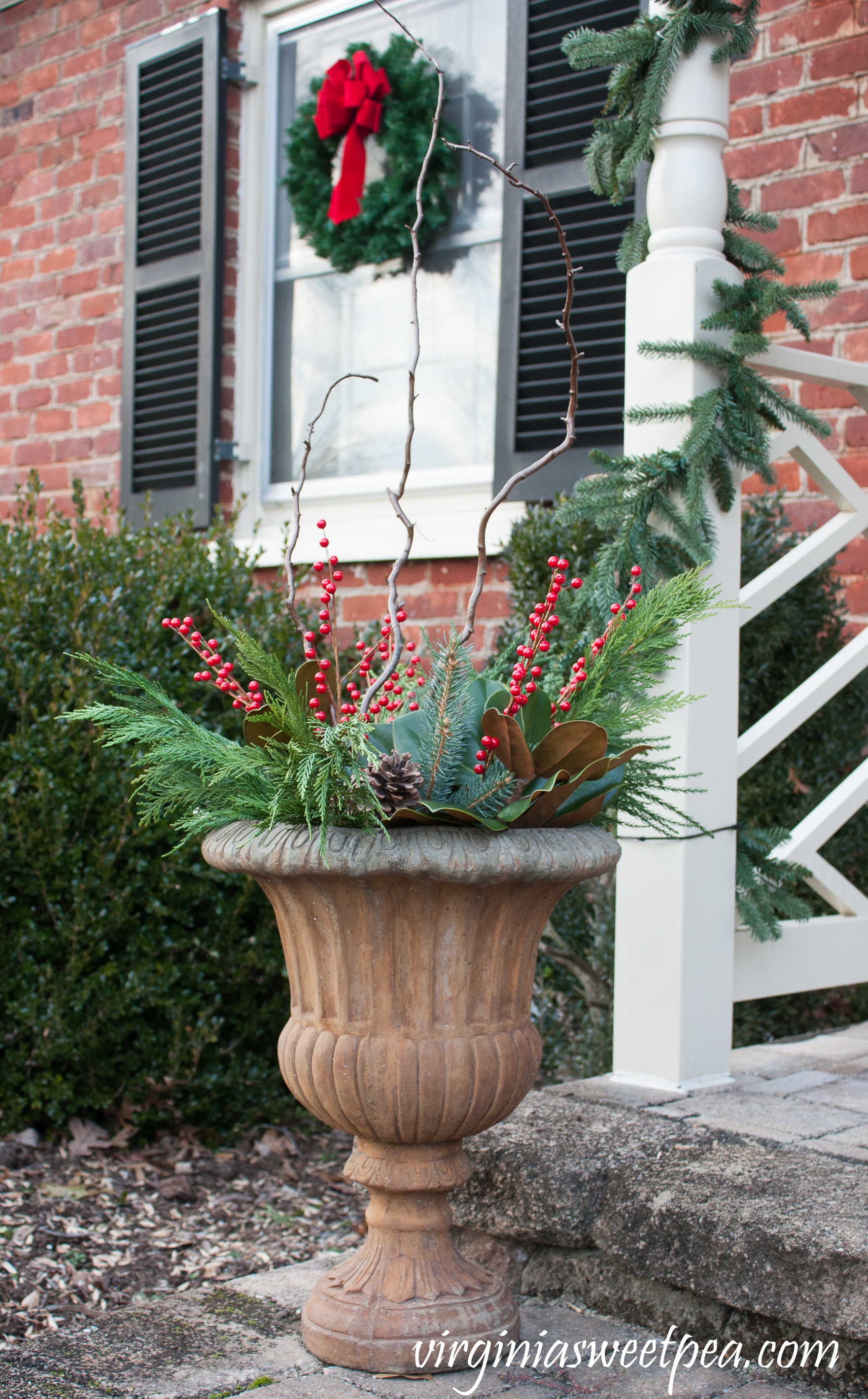 Christmas Front Porch and Holiday Door Decor - Urns filled with greenery, berries, and curly willow for Christmas. #christmas #christmasurns #christmasdoors #christmasoutdoors #christmasdecor