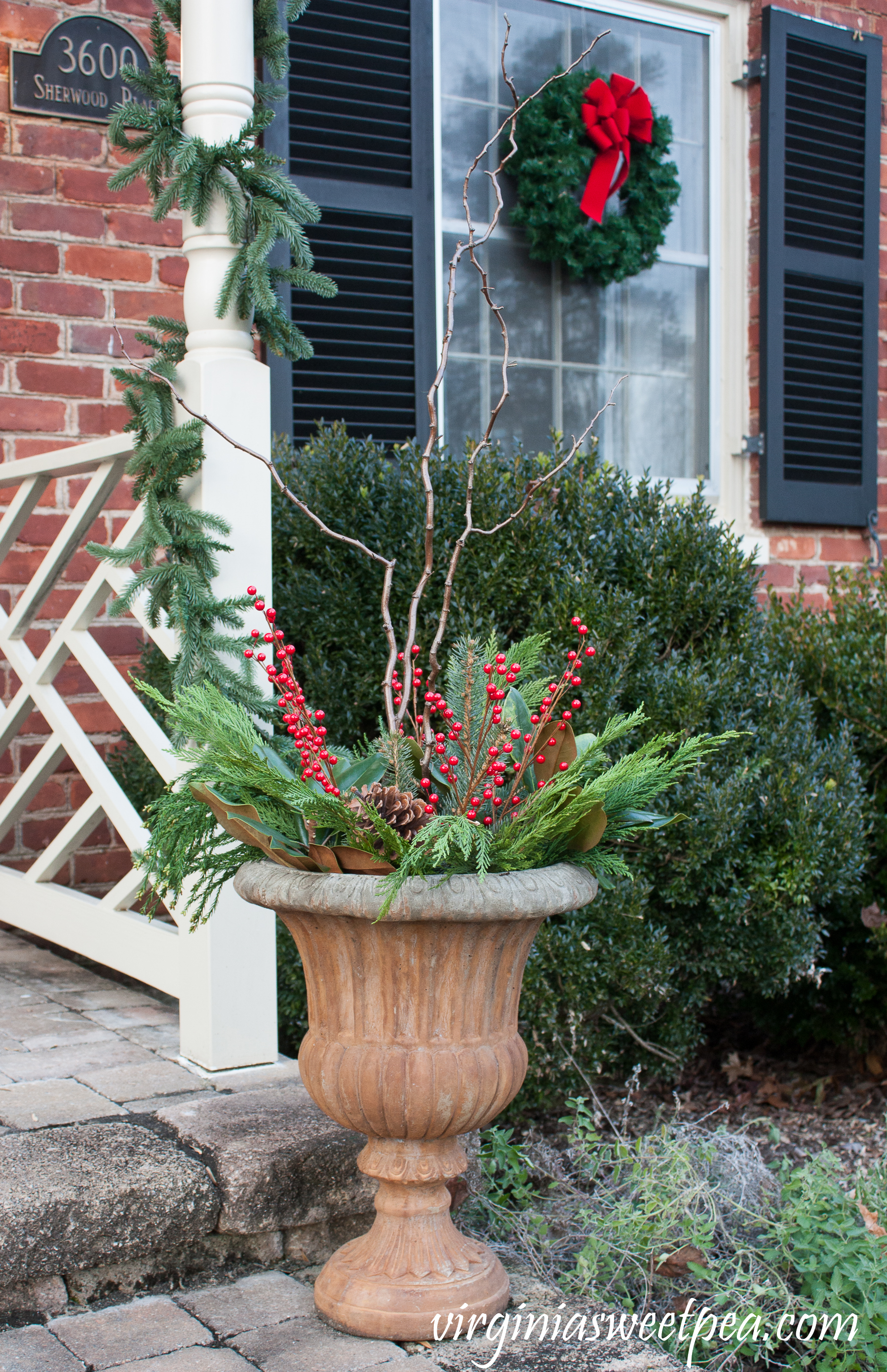 Christmas Front Porch and Holiday Door Decor - Urns filled with greenery, berries, and curly willow for Christmas. #christmas #christmasurns #christmasdoors #christmasoutdoors #christmasdecor