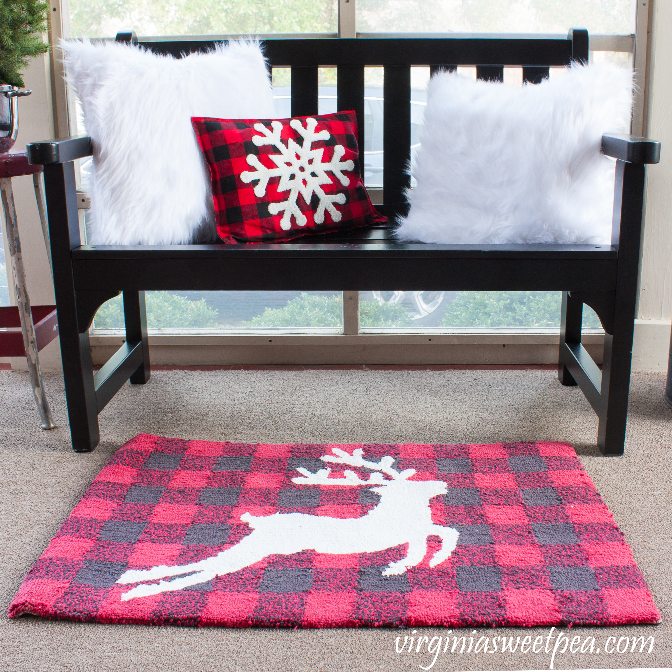 Plow and Hearth bench decorated for Christmas with fur pillow covers, a buffalo check snowflake pillow, and coordinating reindeer rug. #christmas #christmasdecorating #christmasporch