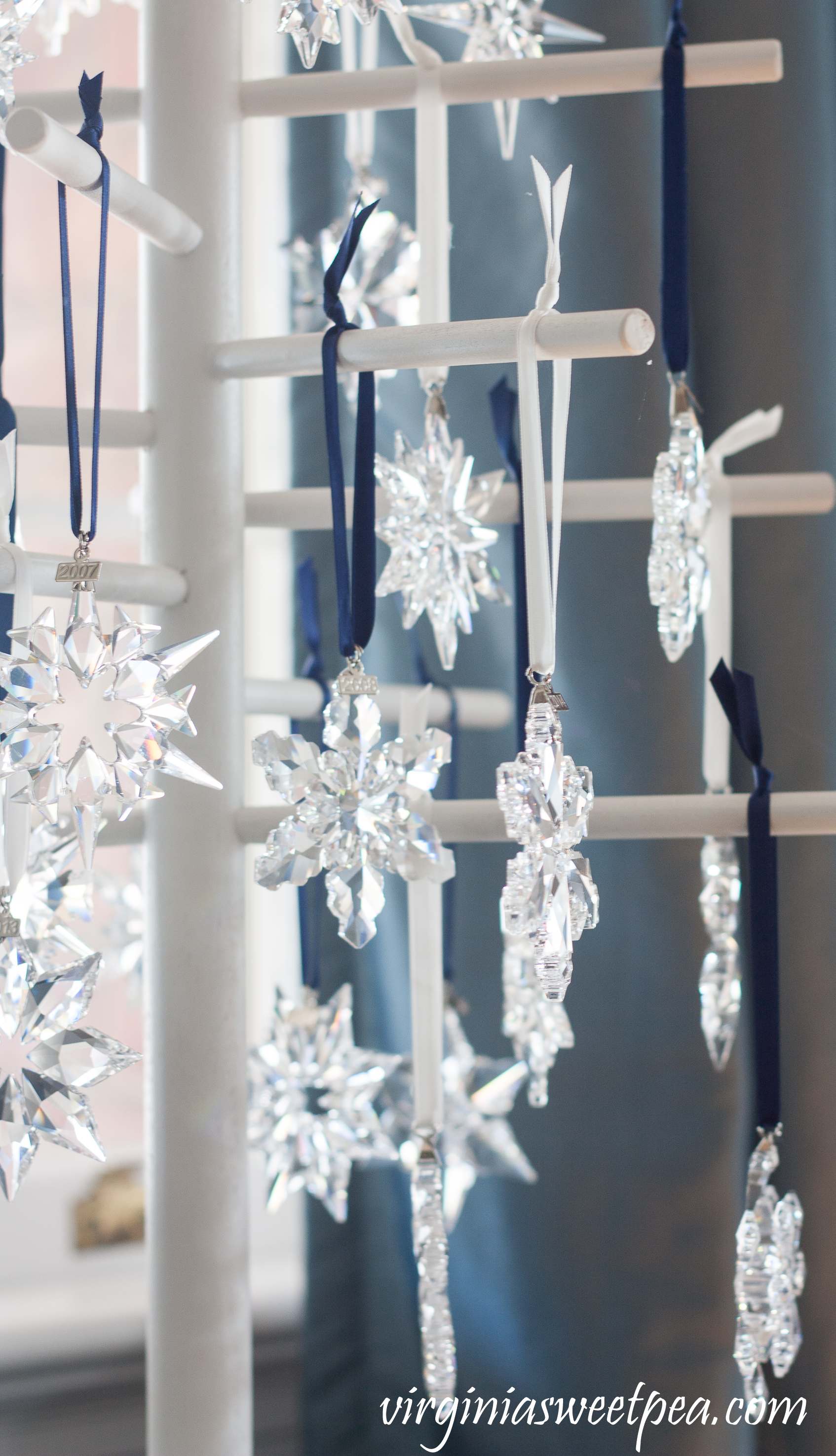 Swarovski Snowflake Ornaments - A collection of snowflakes from 1994 - 2018 is displayed on a wooden tree. #swarovski #swarovskiornaments #swarovskisnowflakeornaments