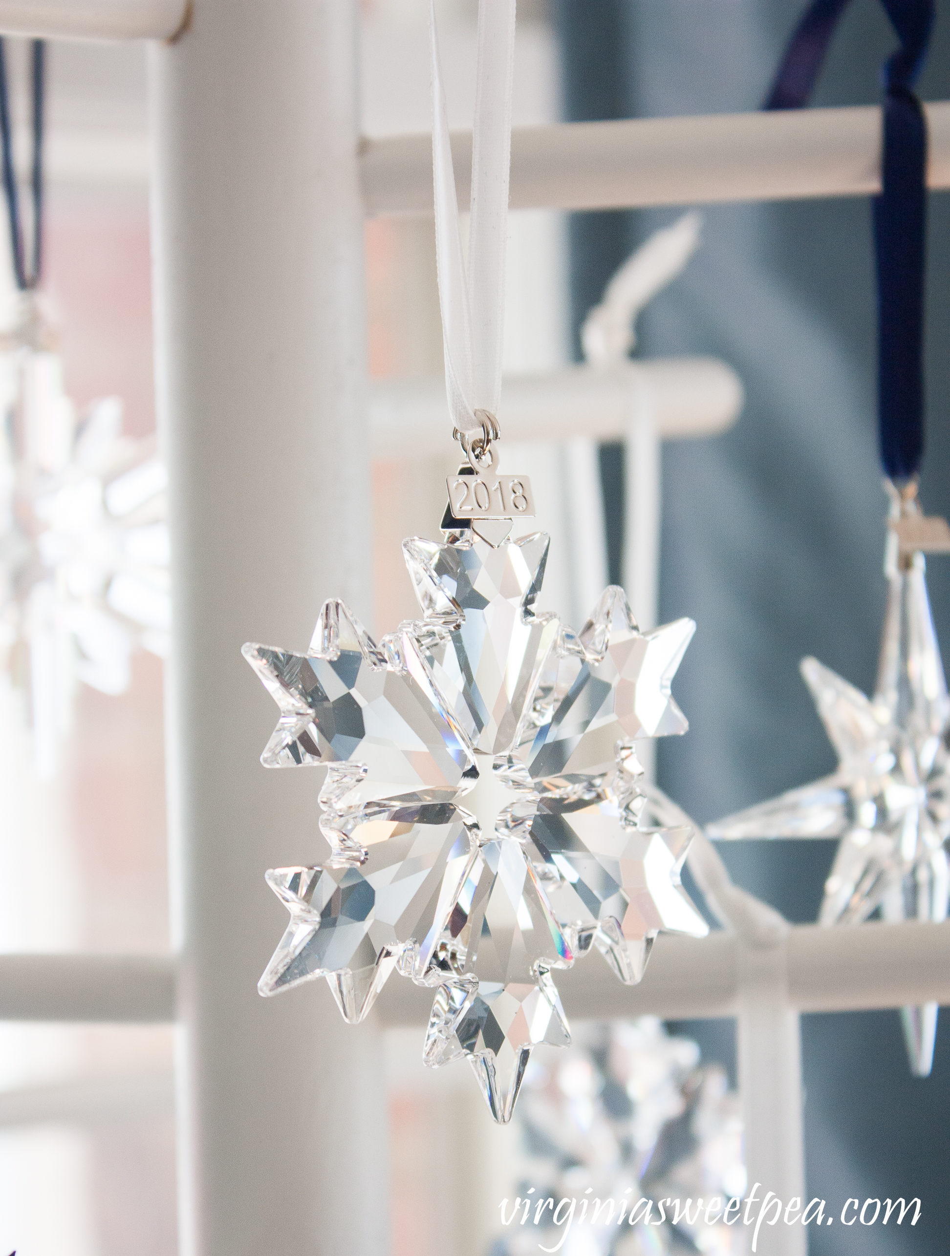 Swarovski Snowflake Ornaments - A collection of snowflakes from 1994 - 2018 is displayed on a wooden tree. #swarovski #swarovskiornaments #swarovskisnowflakeornaments