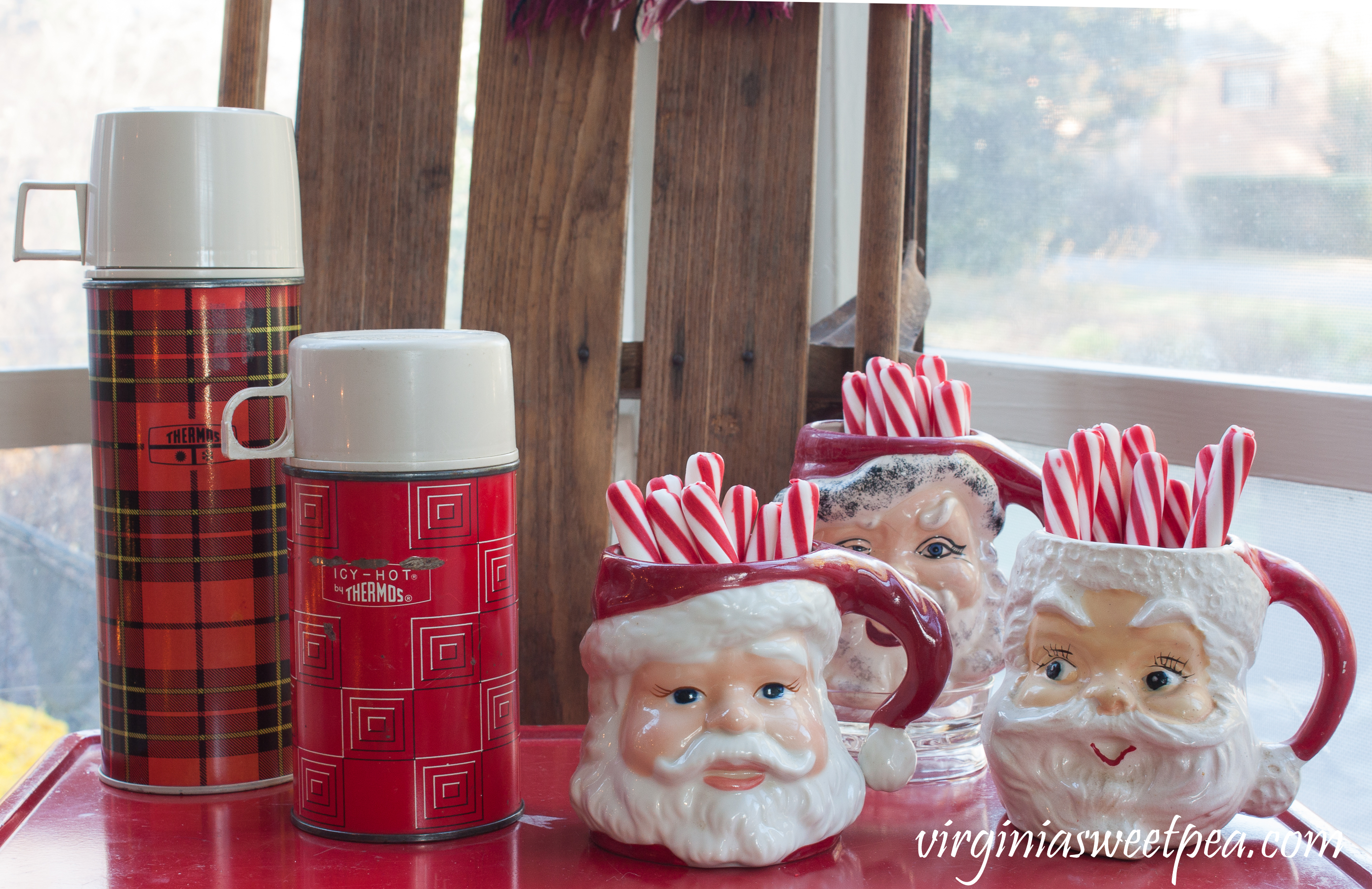 Christmas Porch Vignette - Vintage thermoses with Santa mugs. #christmas #christmasdecorations #christmasporch #vintage #vintagechristmas