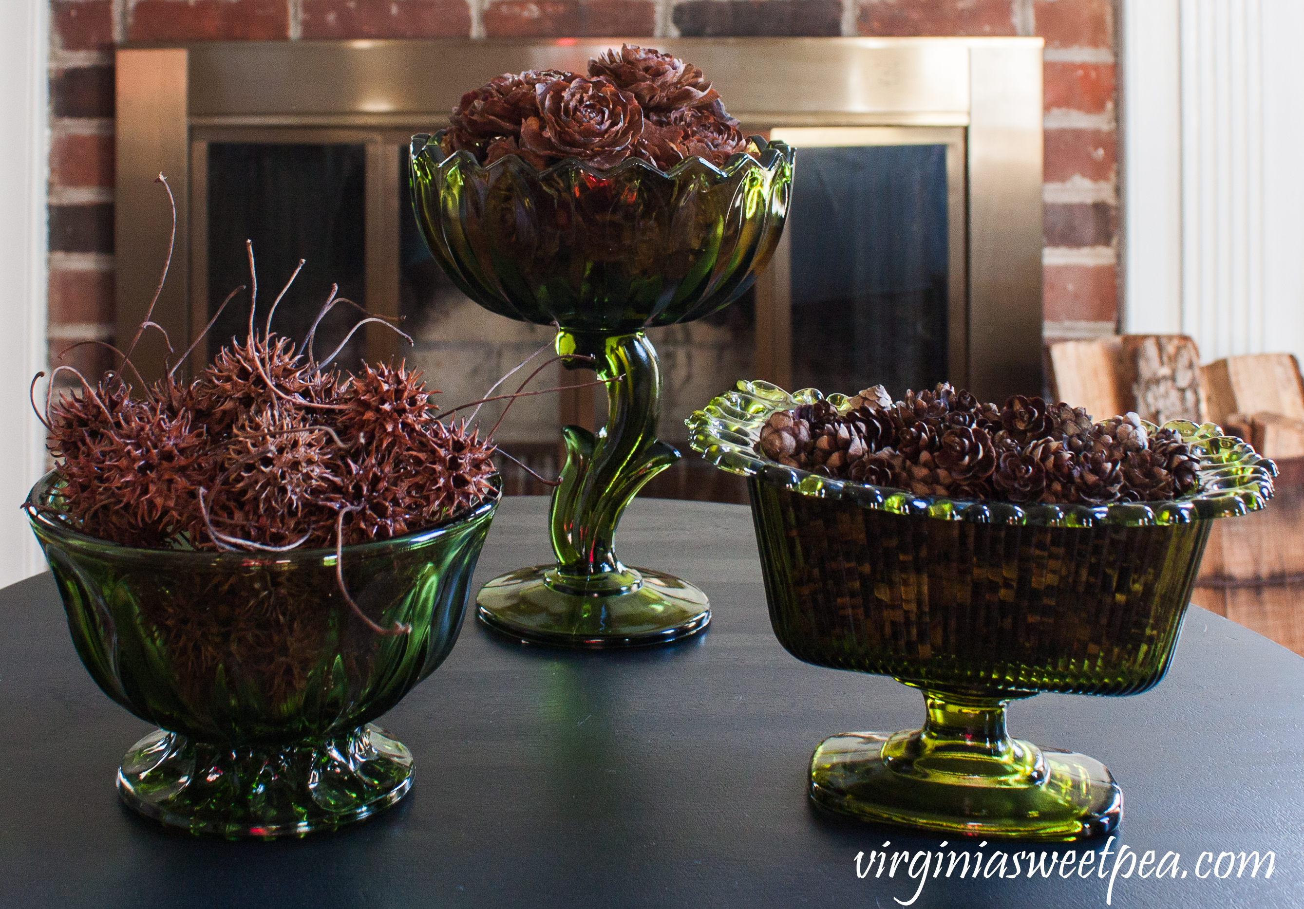 Three vintage green vases are filled with items from nature including Deodora Cedar cones, Hemlock cones, and Sweet Gum seed pods. #vintagegreenglass #deodoracedar #hemlockcone #sweetgumtree