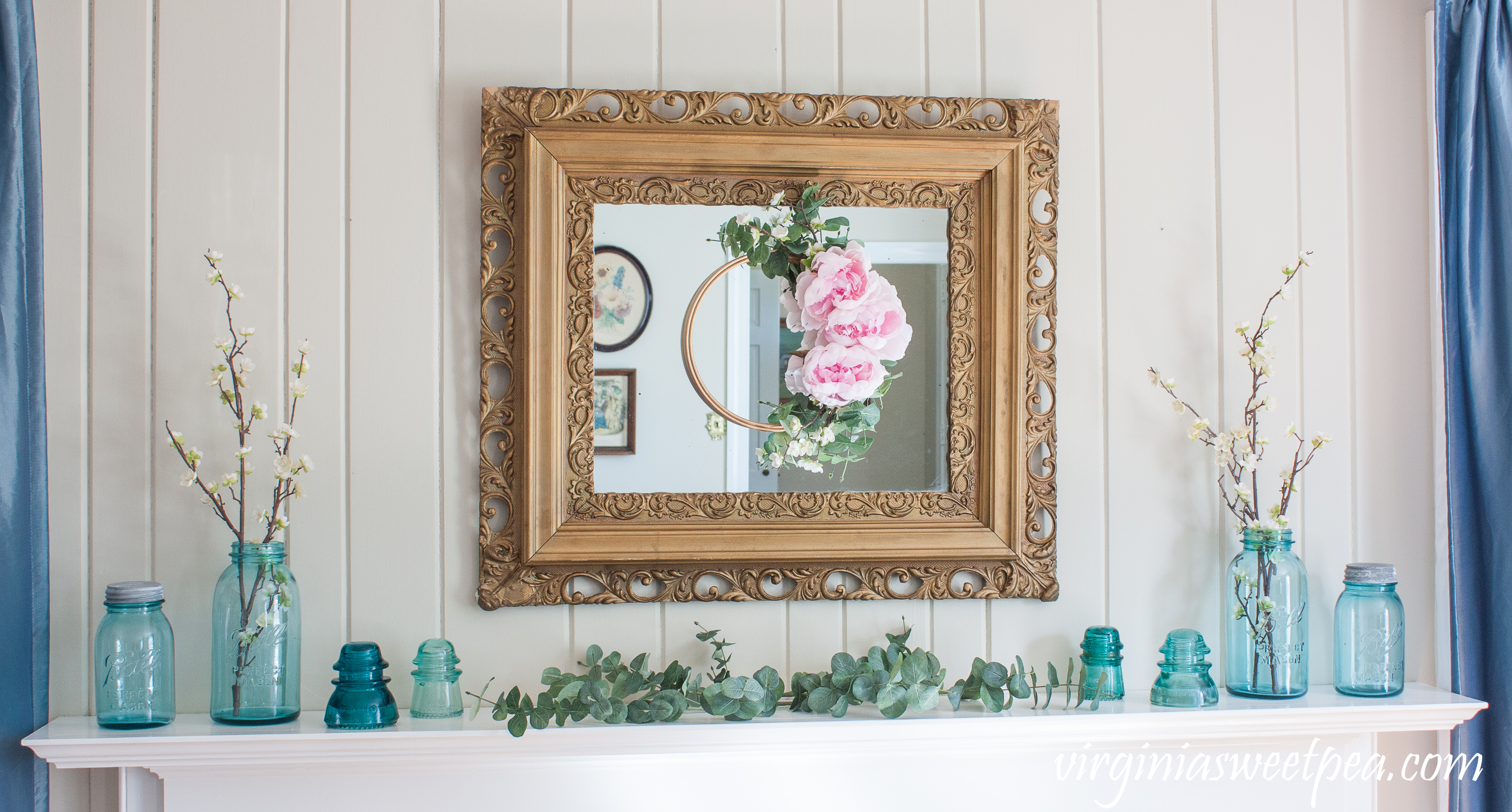 Spring Mantel and DIY Embroidery Hoop Wreath - A mantel is decorated for spring with vintage blue Ball jars and insulators. #spring #springdecor #springmantel #wreath #springwreath #vintage #balljars #vintagedecor