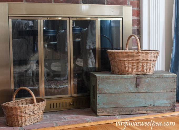 Vintage Baskets used on a fireplace hearth with a vintage toolbox