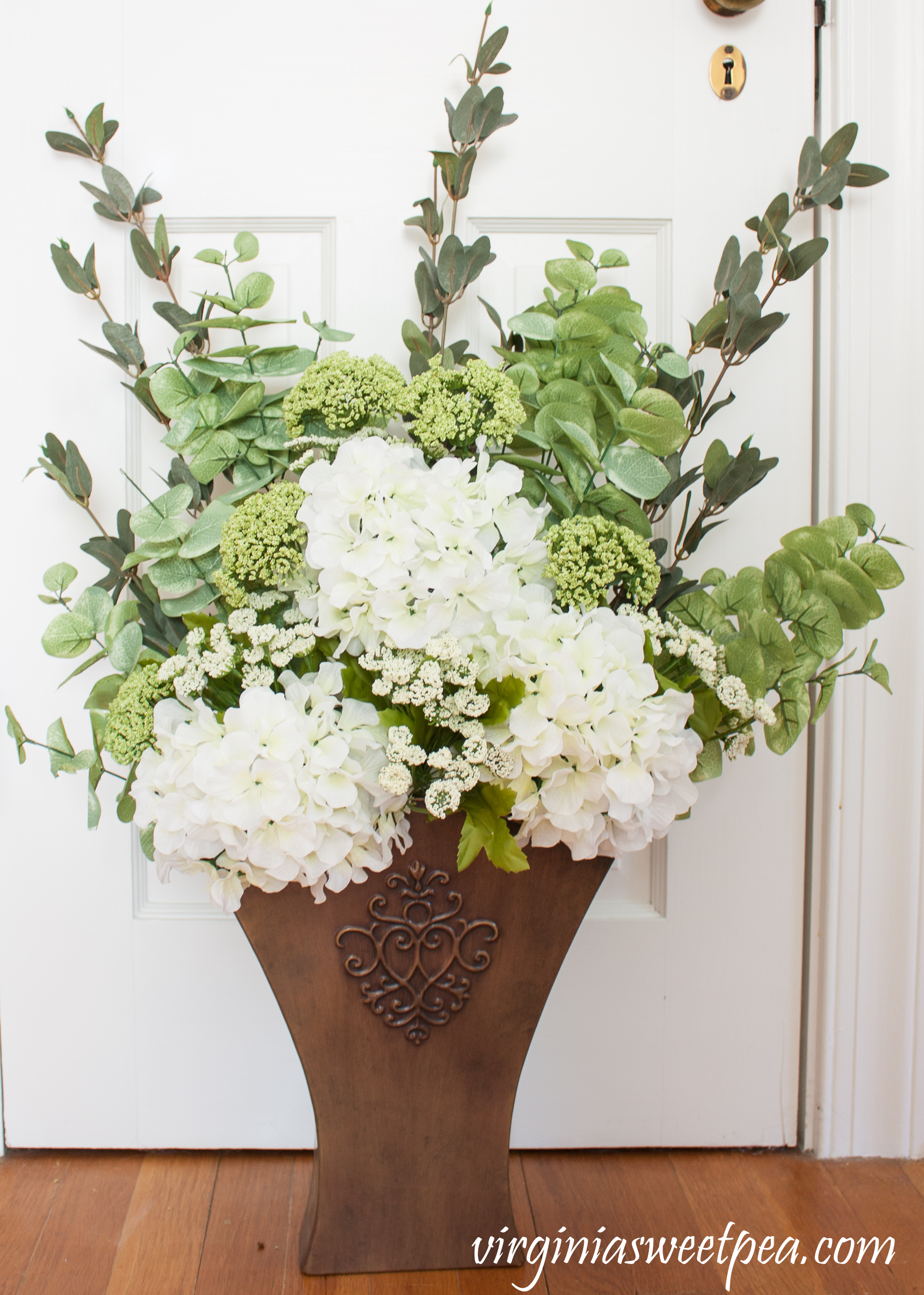 DIY Spring Floral Display - Learn how to make a floral display like this to display in your home. This would look great hanging on a door or on a porch wall. #springdecor #springfloralarrangement #springwreath #springdecorating