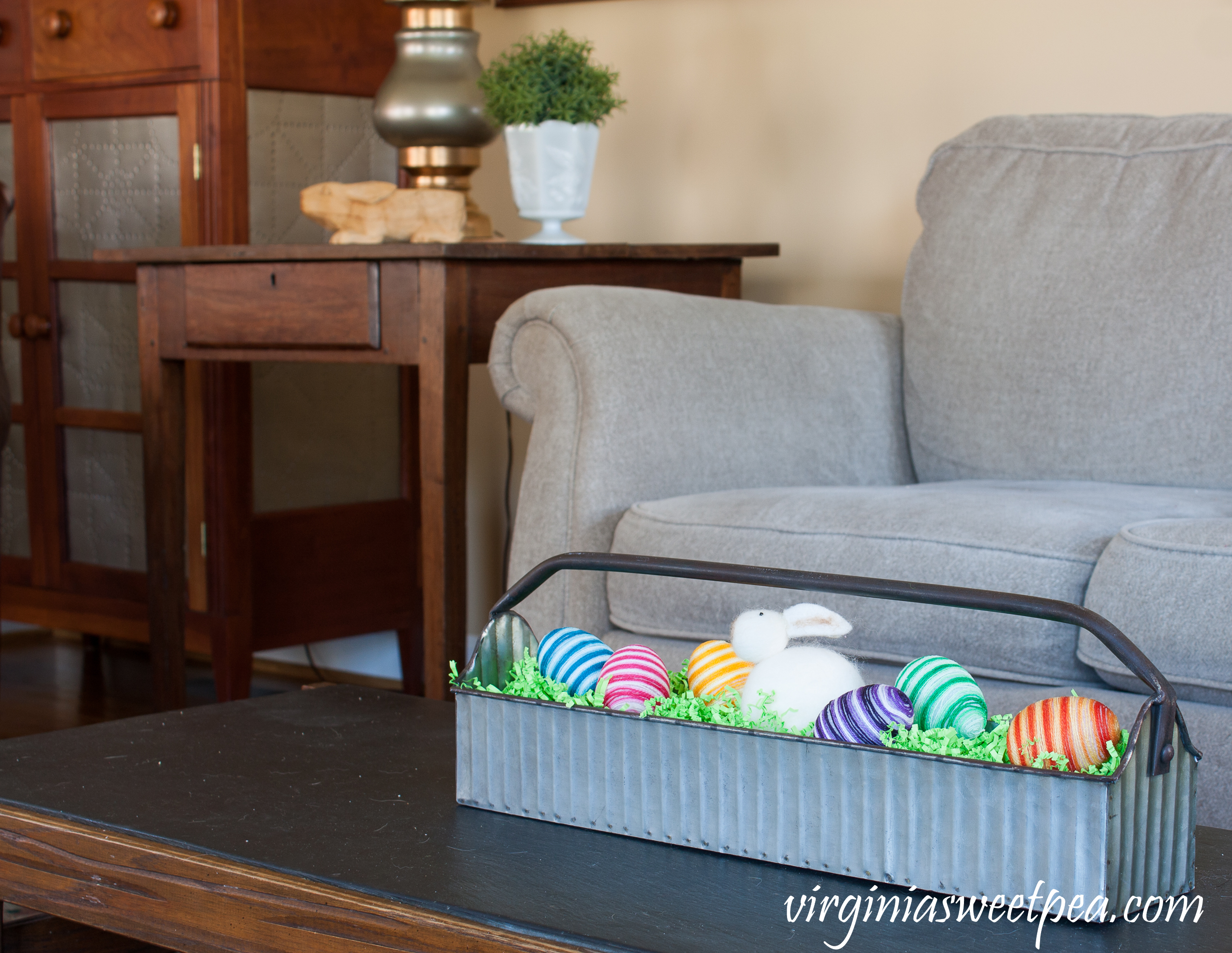 Easter in the Family Room - Metal tool caddy decorated for Easter with handmade striped eggs and a stuffed Easter rabbit