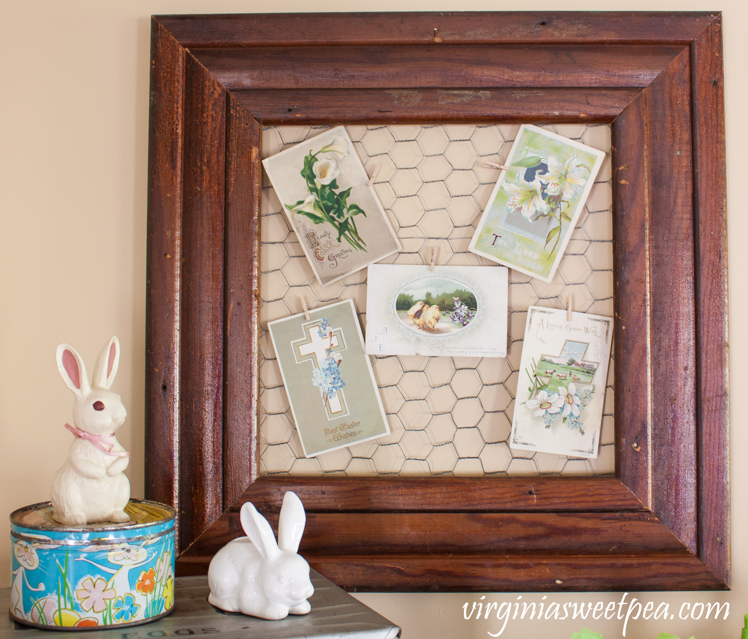 Vintage Easter postcards displayed with rabbits and a 1960's Easter candy tin.
