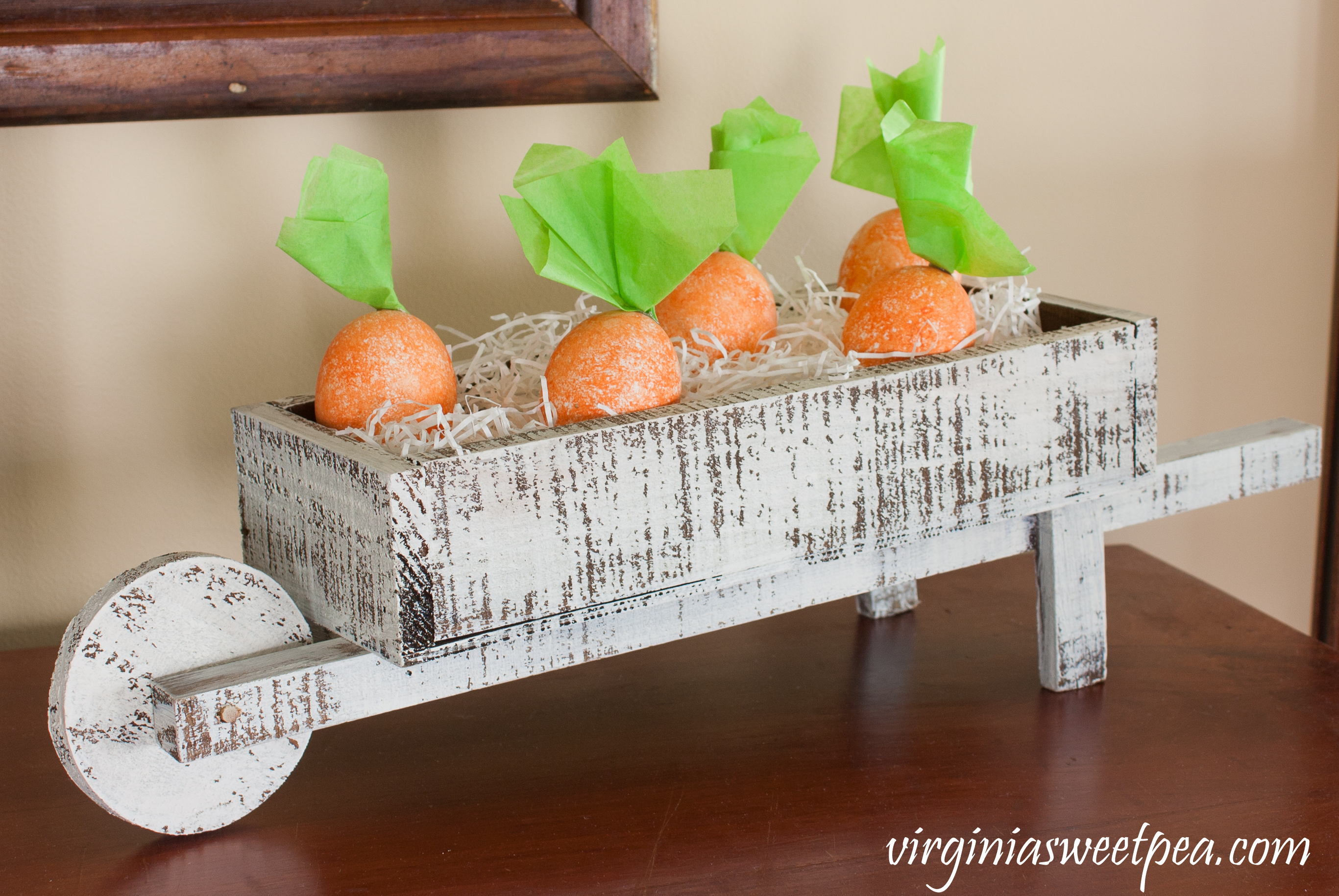 Easter Centerpiece - Small wheelbarrow filled with white paper shreds and carrot Easter eggs