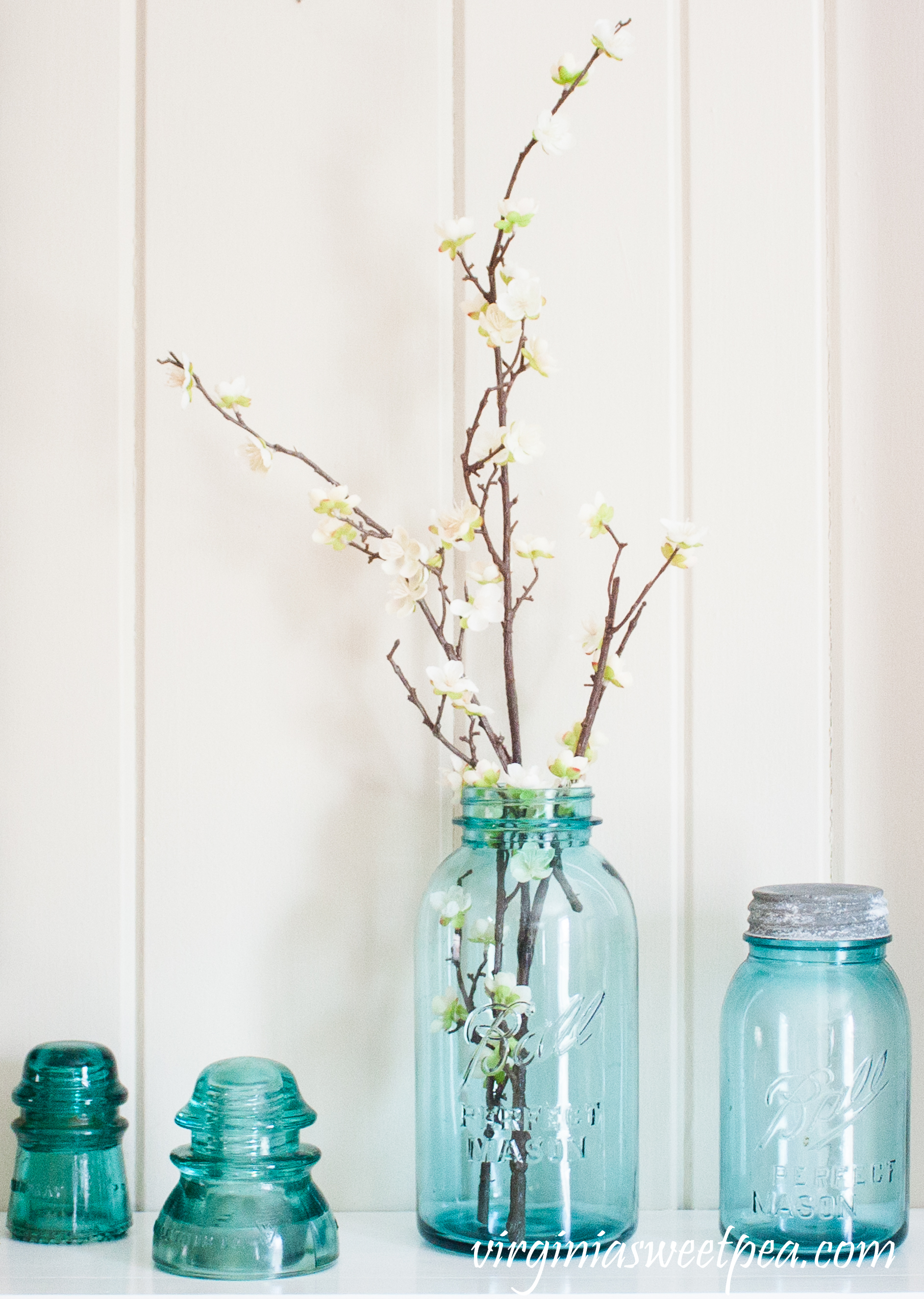 Vintage Blue Ball Jars and Insulators used on a Spring Mantel - #springmantel #springdecor #vintage #vintagedecor #balljars