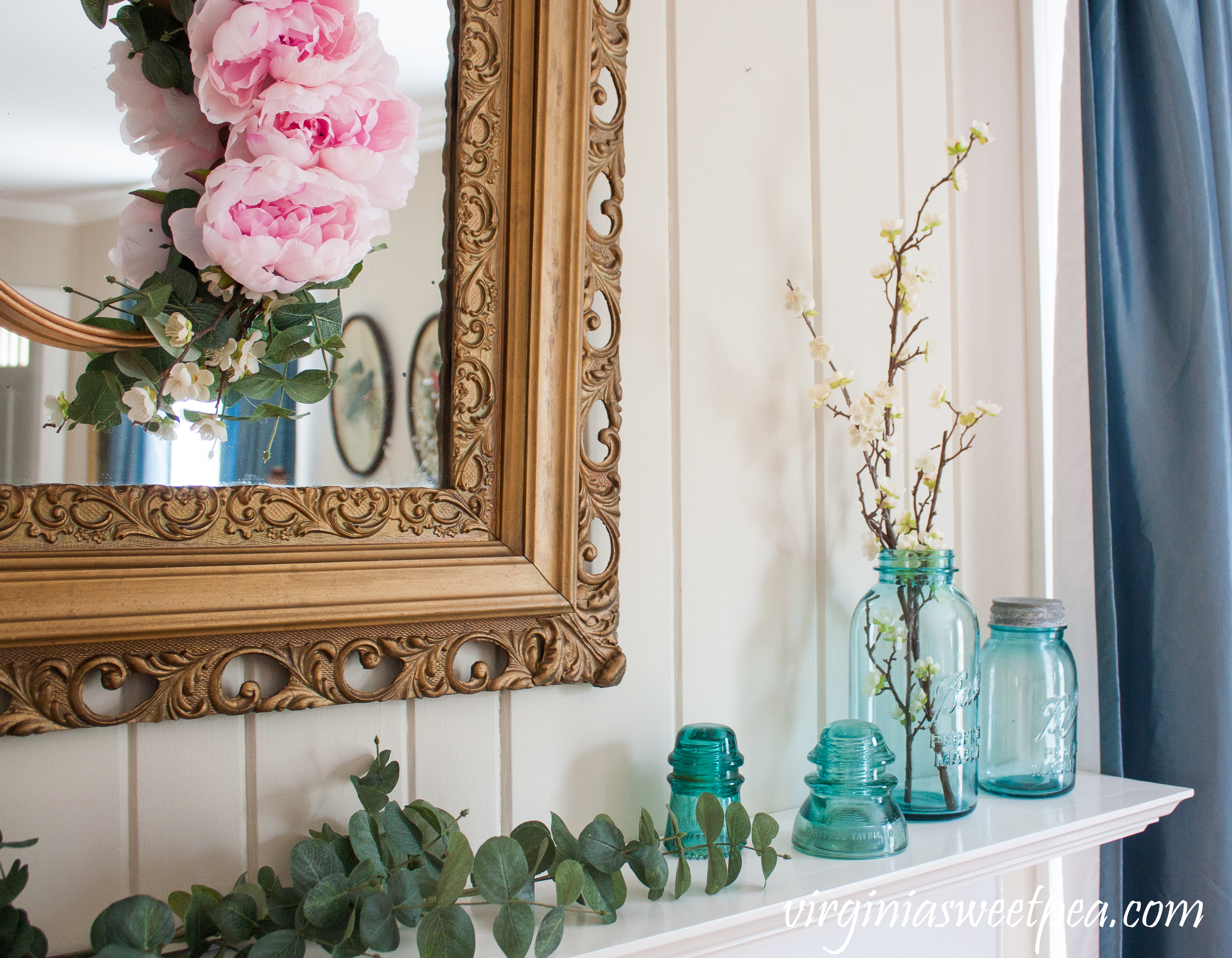 Spring Mantel decorated with vintage blue Ball jars, vintage glass insulators, Eucalyptus, and an antique mirror topped with a Peony hoop wreath