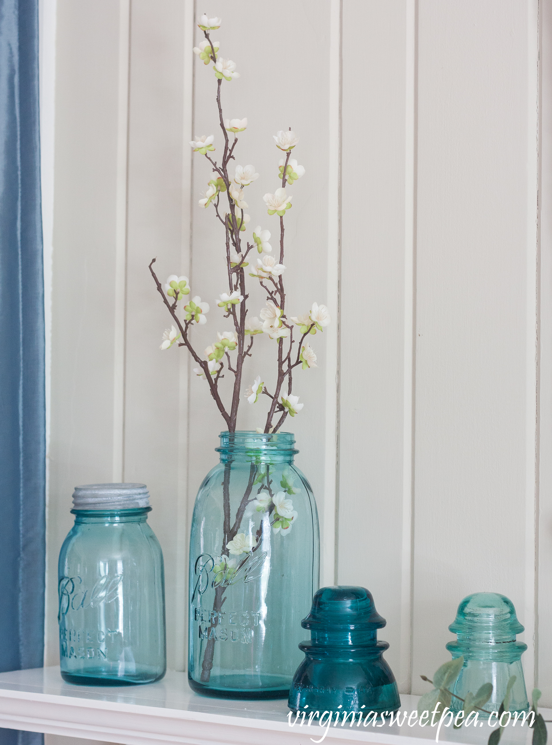 Vintage 1923-33 blue Ball jars and insulators used on a spring mantel. #spring #springmantel #balljars #vintage #vintagedecor #springdecor