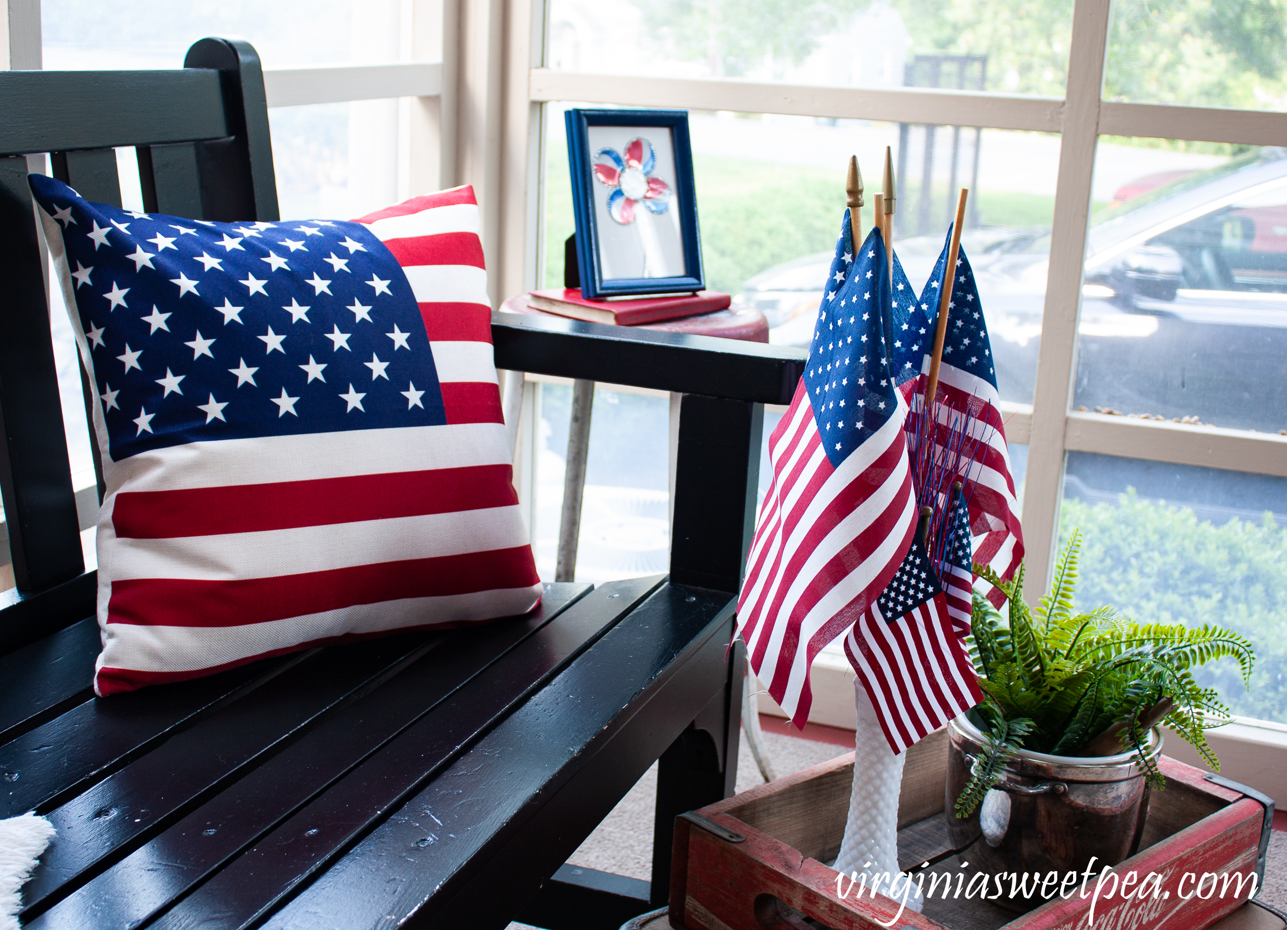 American flag pillow, American flags displayed in a milk glass, vase, adn a Coke crate