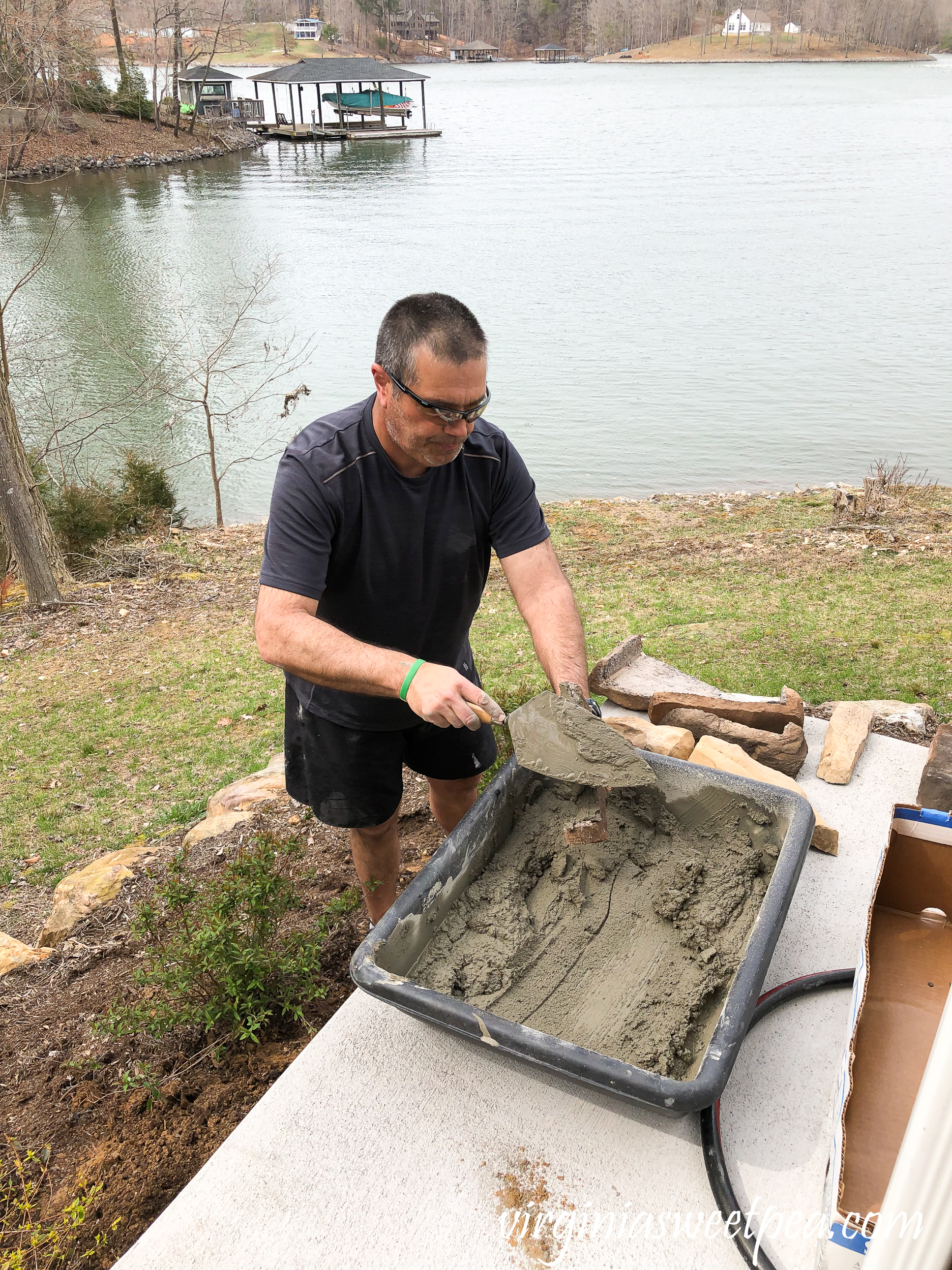 Mixing concrete to use to add stone veneer added to a patio wall