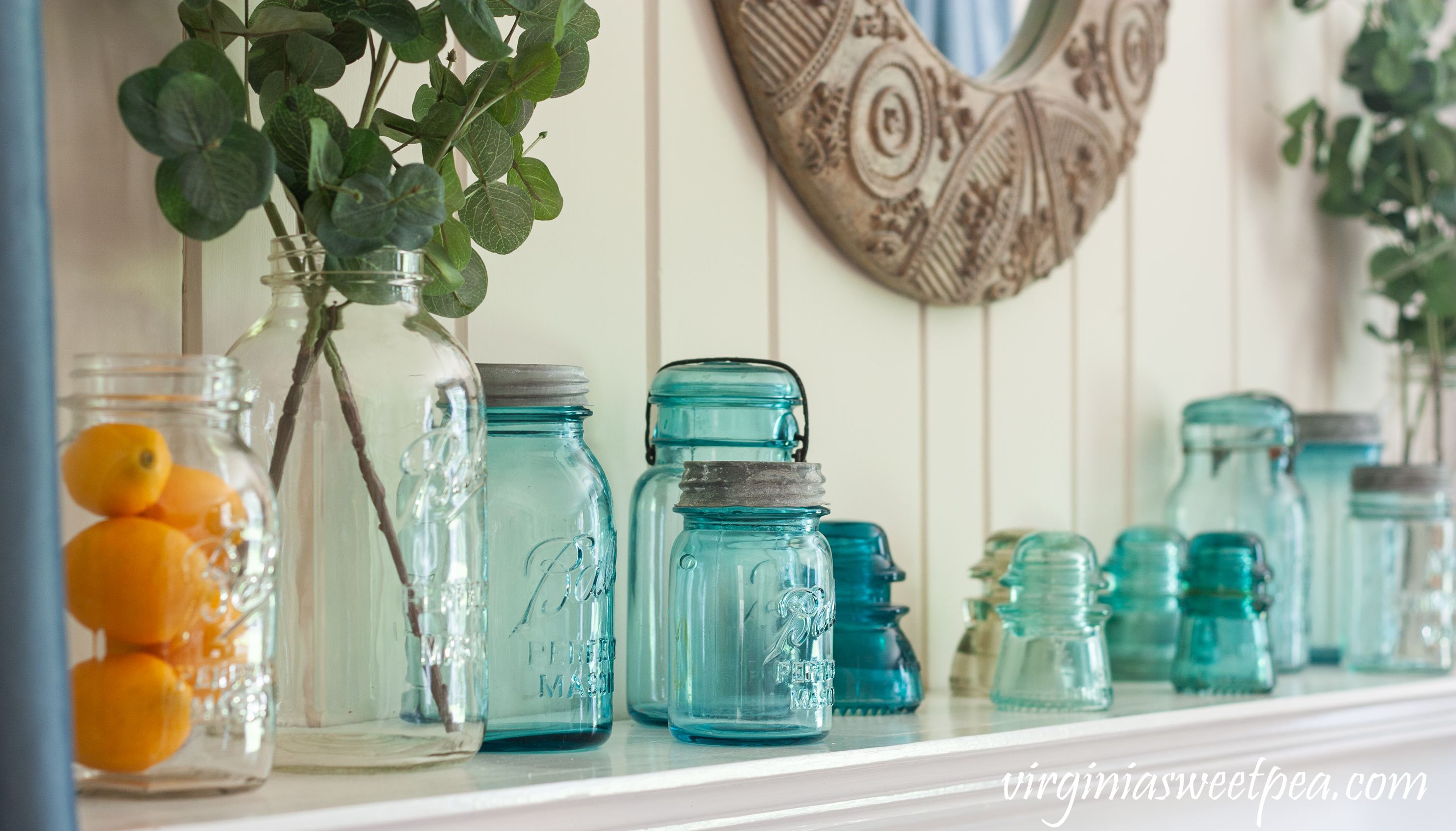 Summer Mantel Decorated with Blue and clear glass Ball Jars, insulators, and lemons.