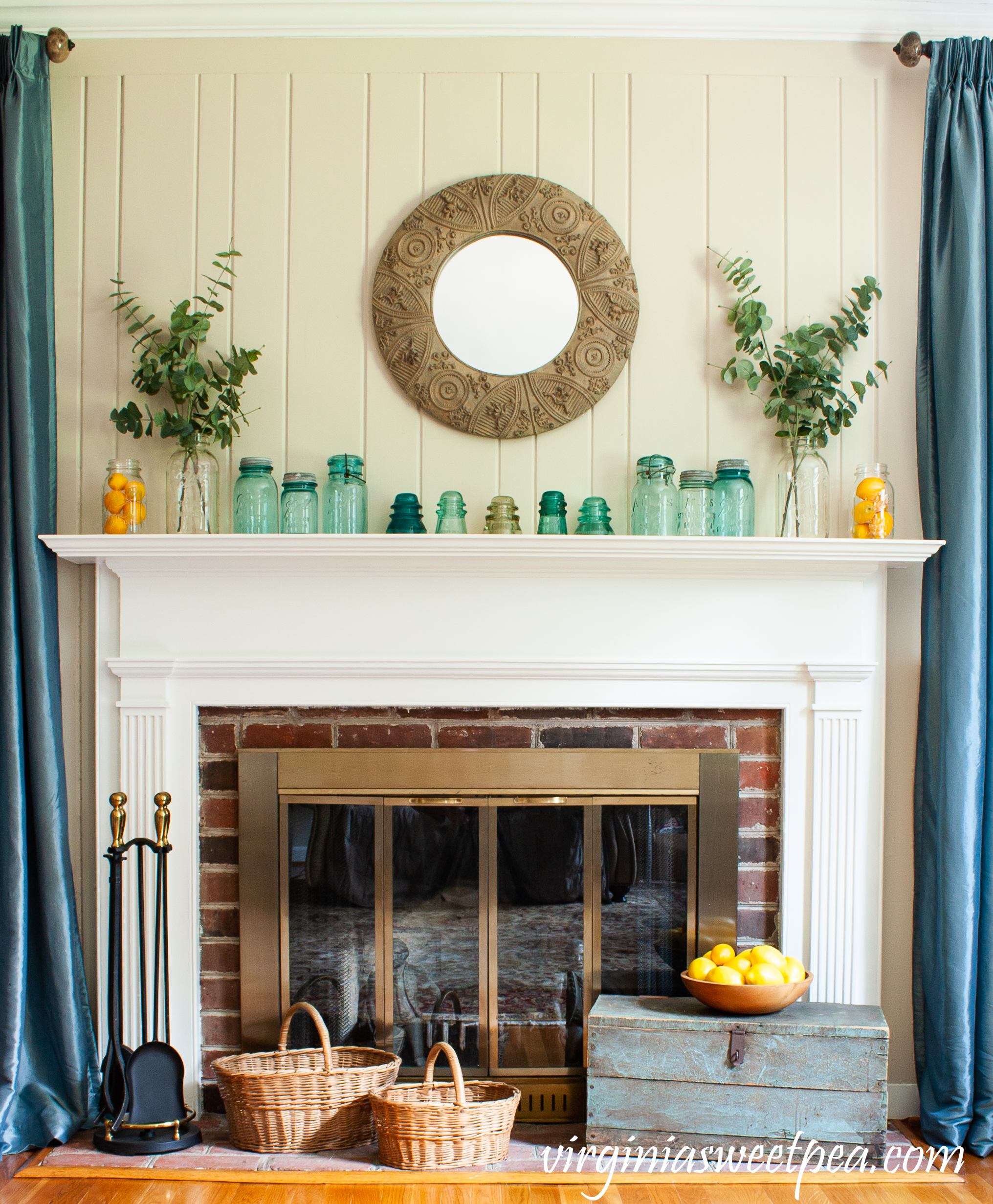 Summer mantel with vintage canning jars, baskets, lemons, eucalyptus, and a vintage tool box.