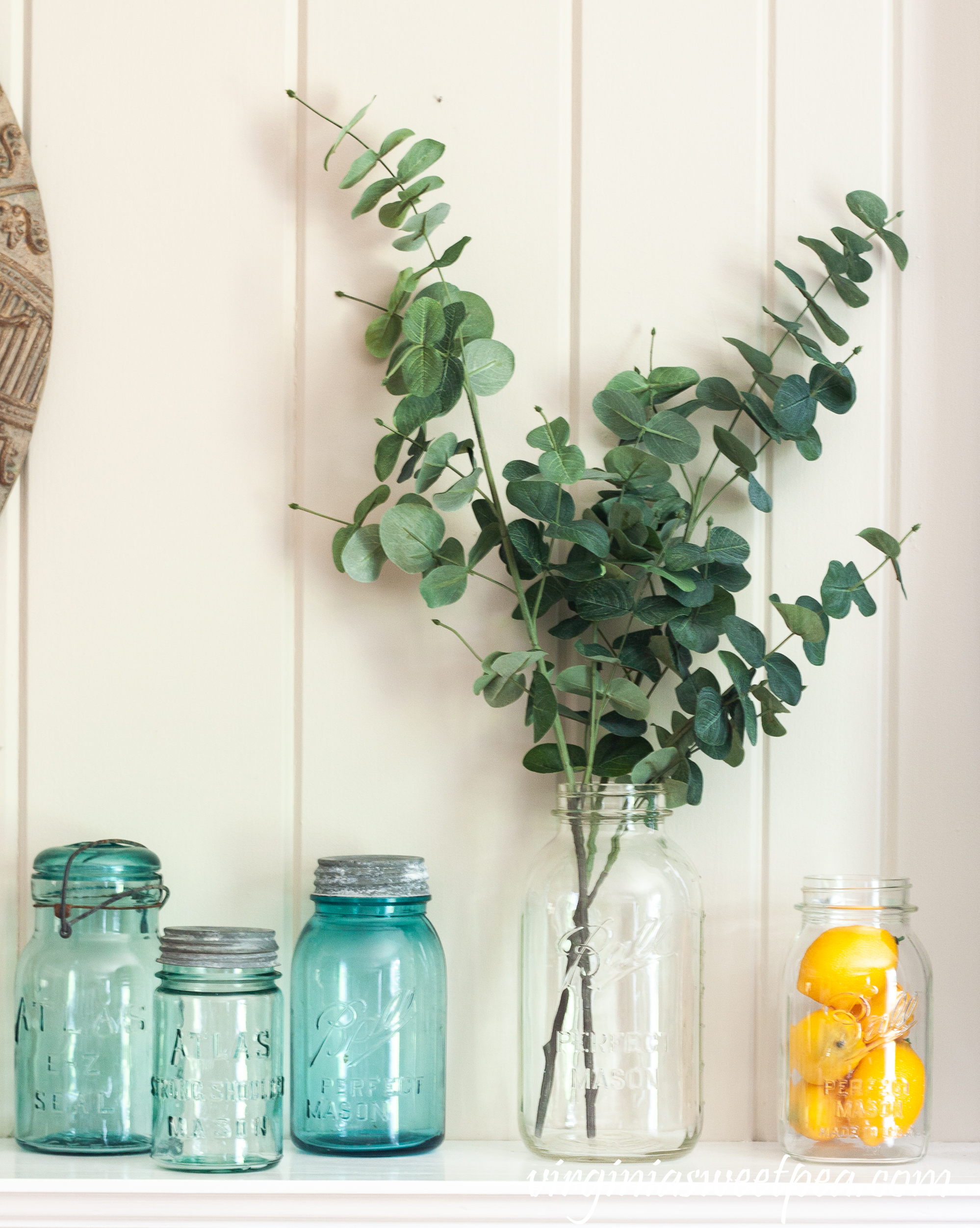 Summer Mantel Decorated with Blue and clear glass Ball Jars, insulators, and lemons.