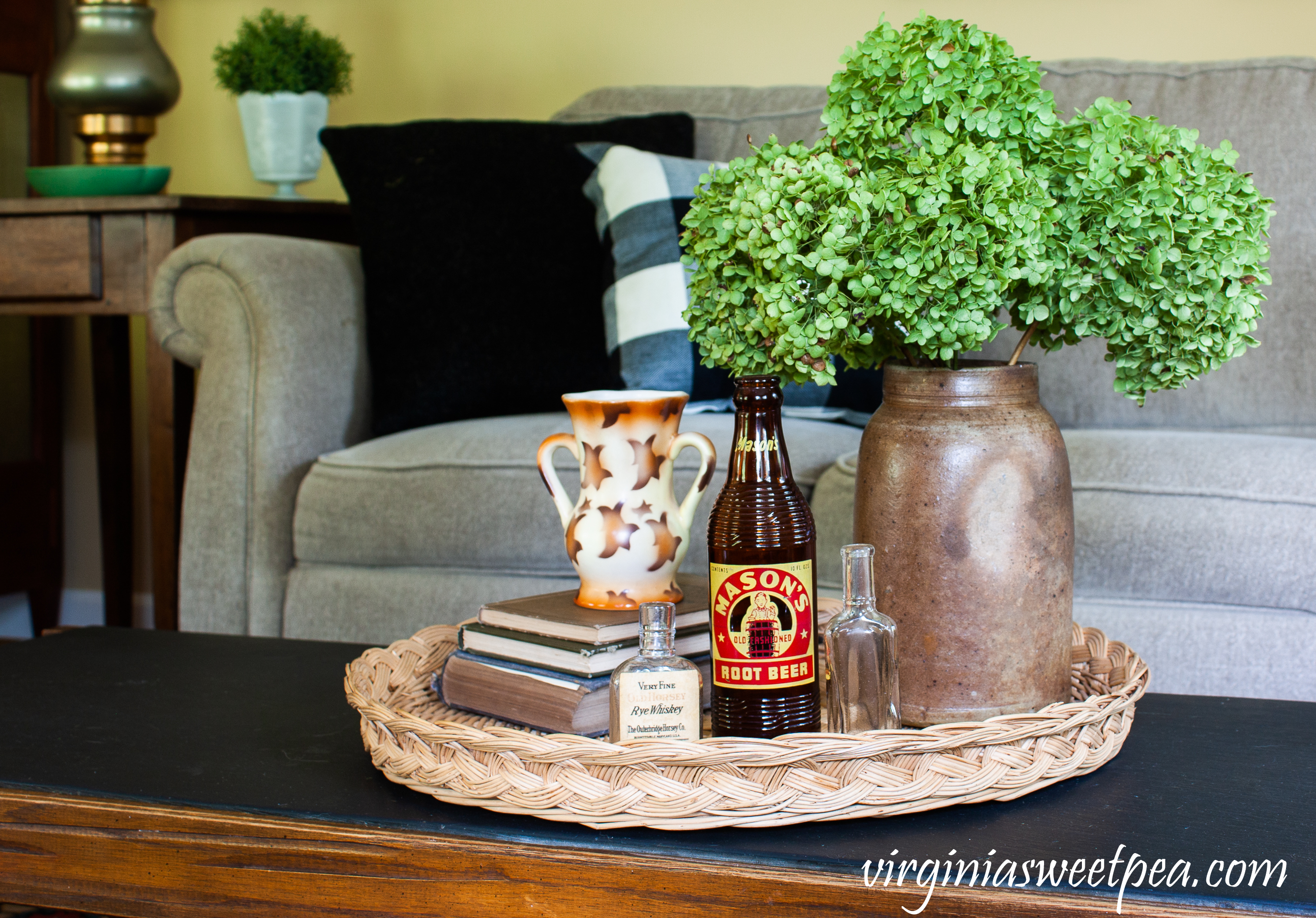 Early fall coffee table vignette with Hydrangeas in an antique crock, vintage bottles books, and a Czechoslovakian vase.