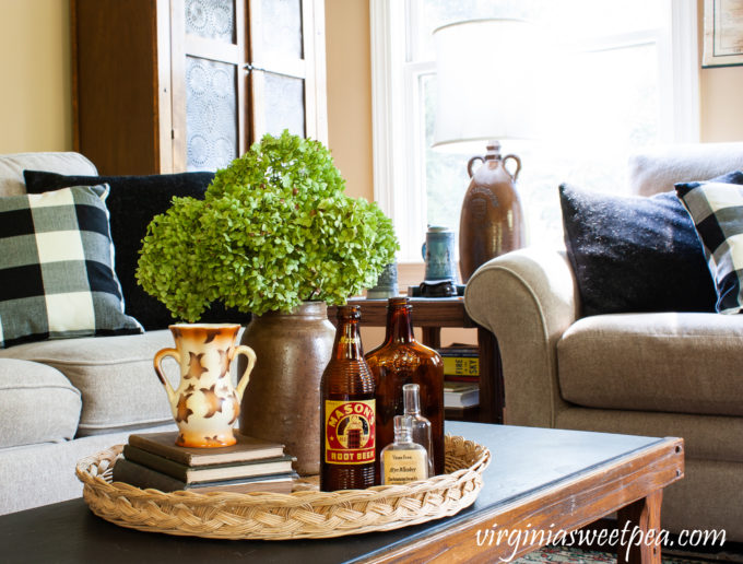 Early Fall coffee table vignette with Hydrangea in an antique crock, vintage bottles and books, and a vintage Czechoslovakian vase.