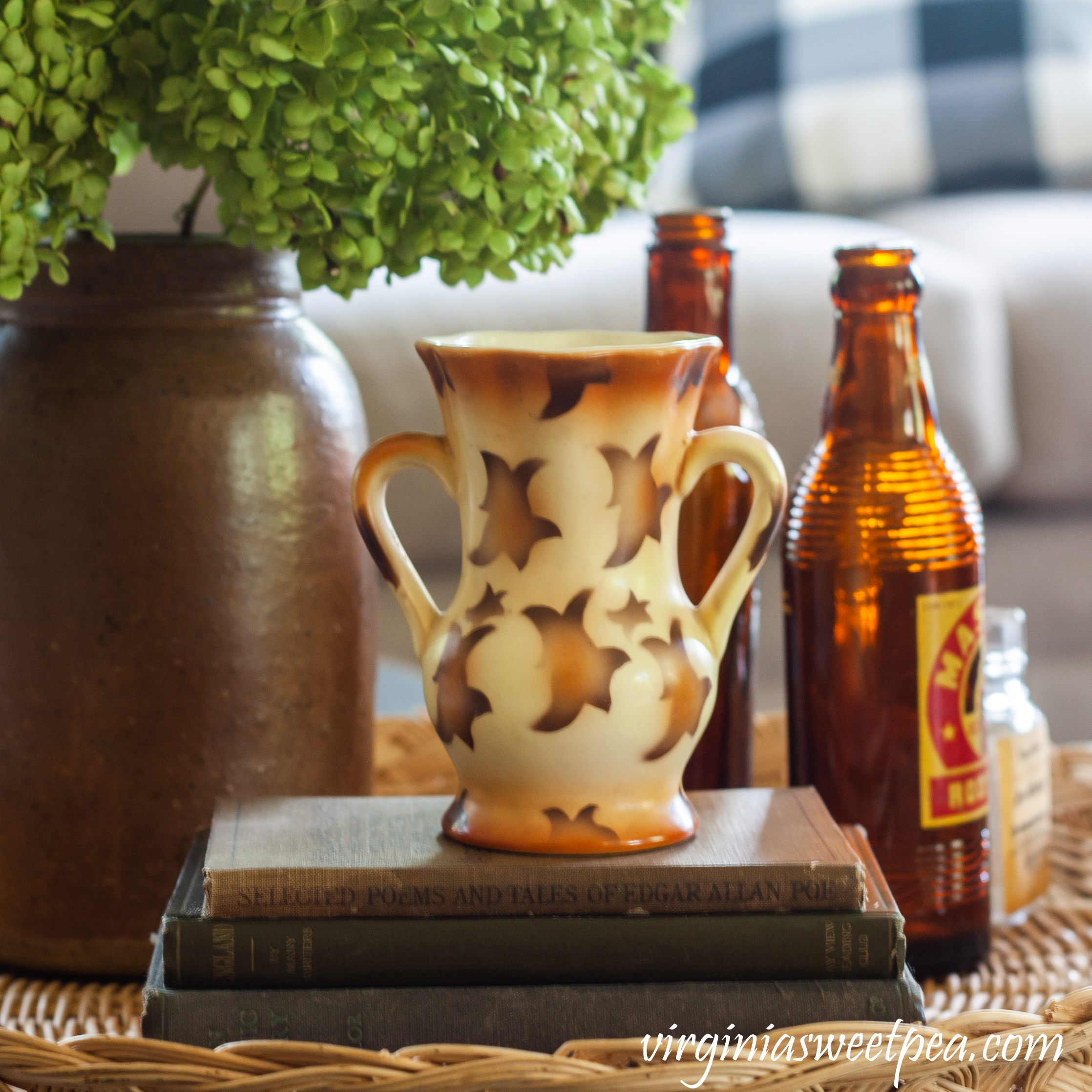 Fall vignette with vintage books and bottles, a Czechoslovakian vase, and a crock filled with Hydrangea.