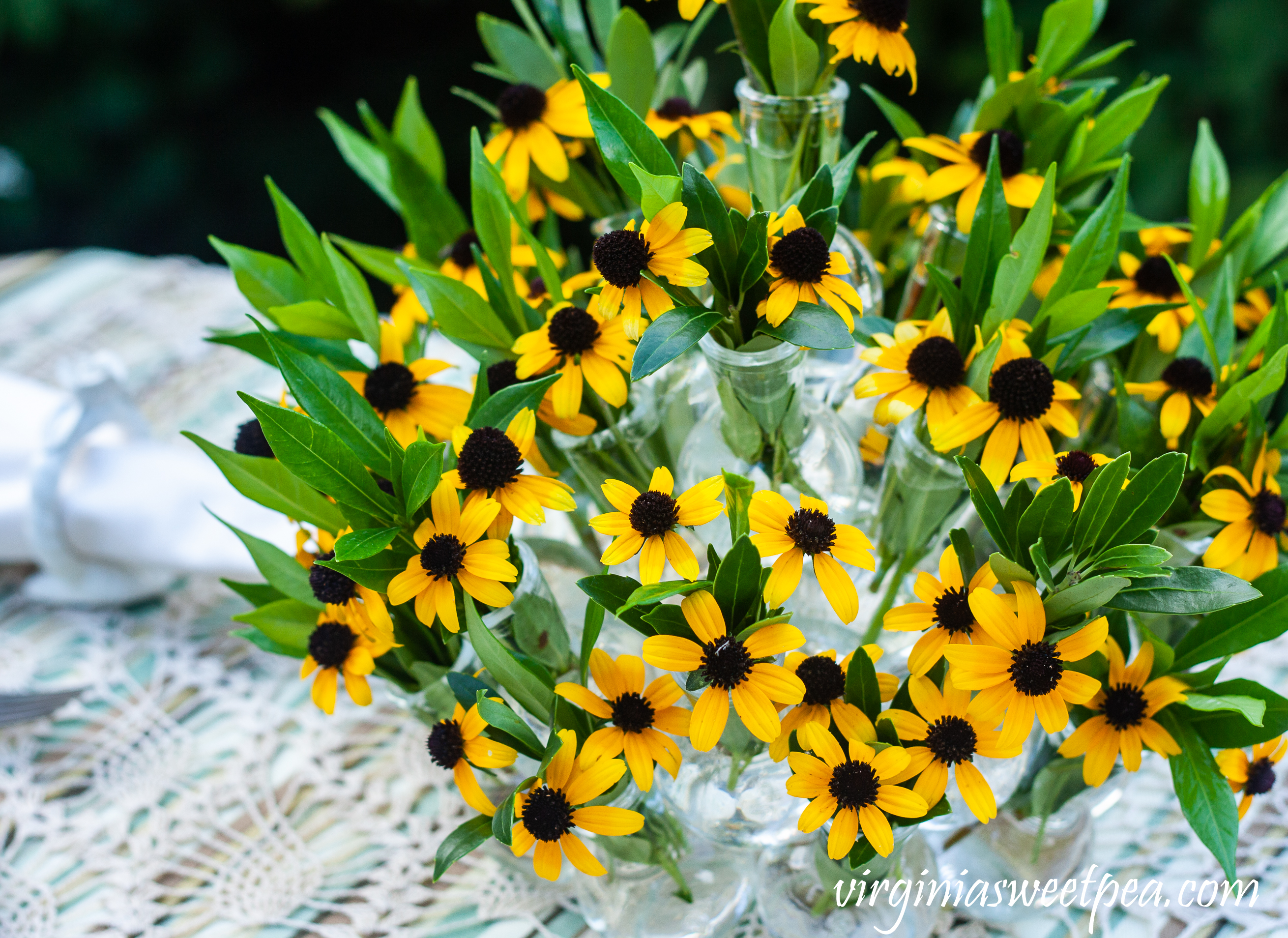 Summer table centerpiece with Rudbeckia and Gardenia foliage