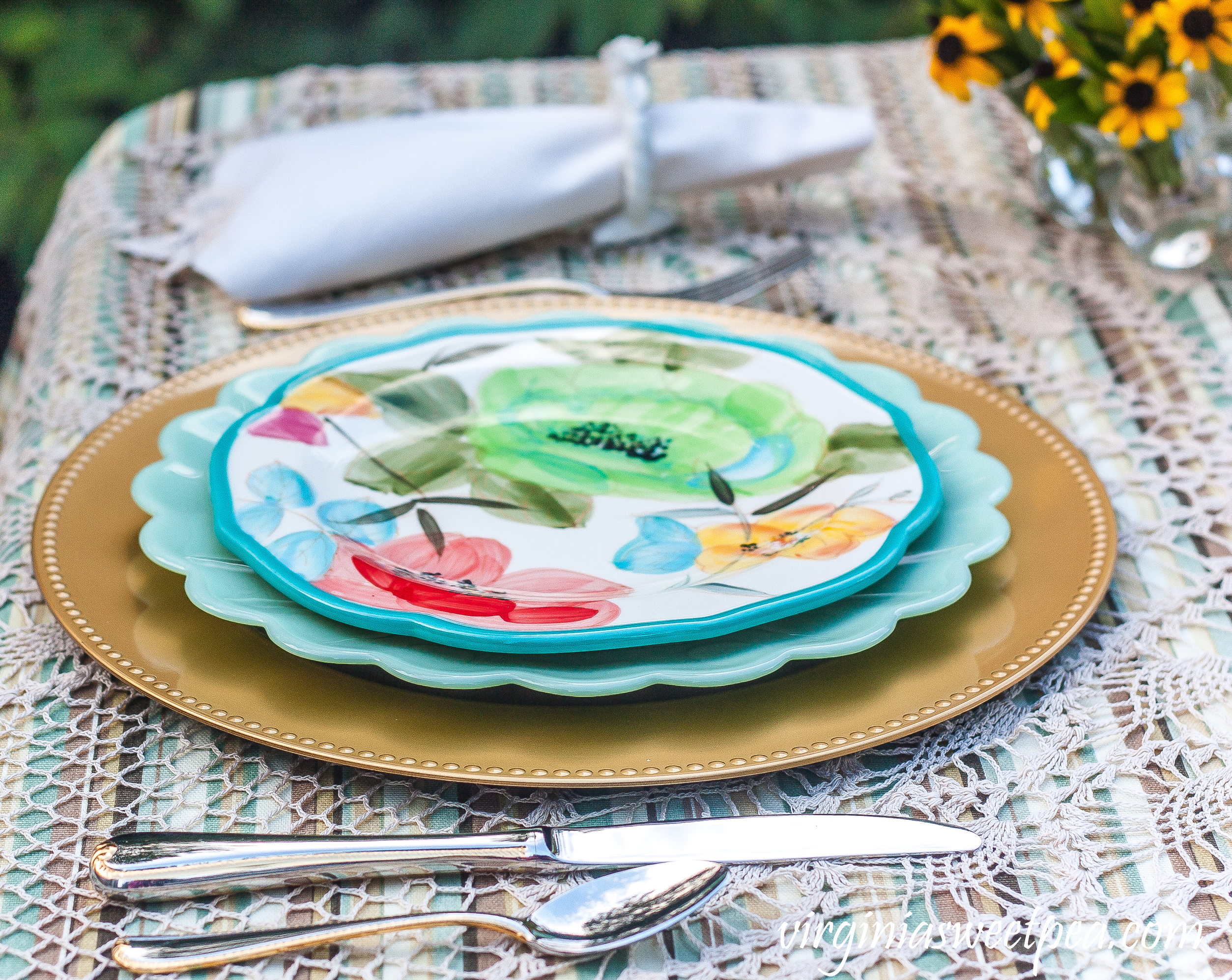 Table setting with Pioneer Woman dishes and Gorham Golden Ribbon Edge flatware.