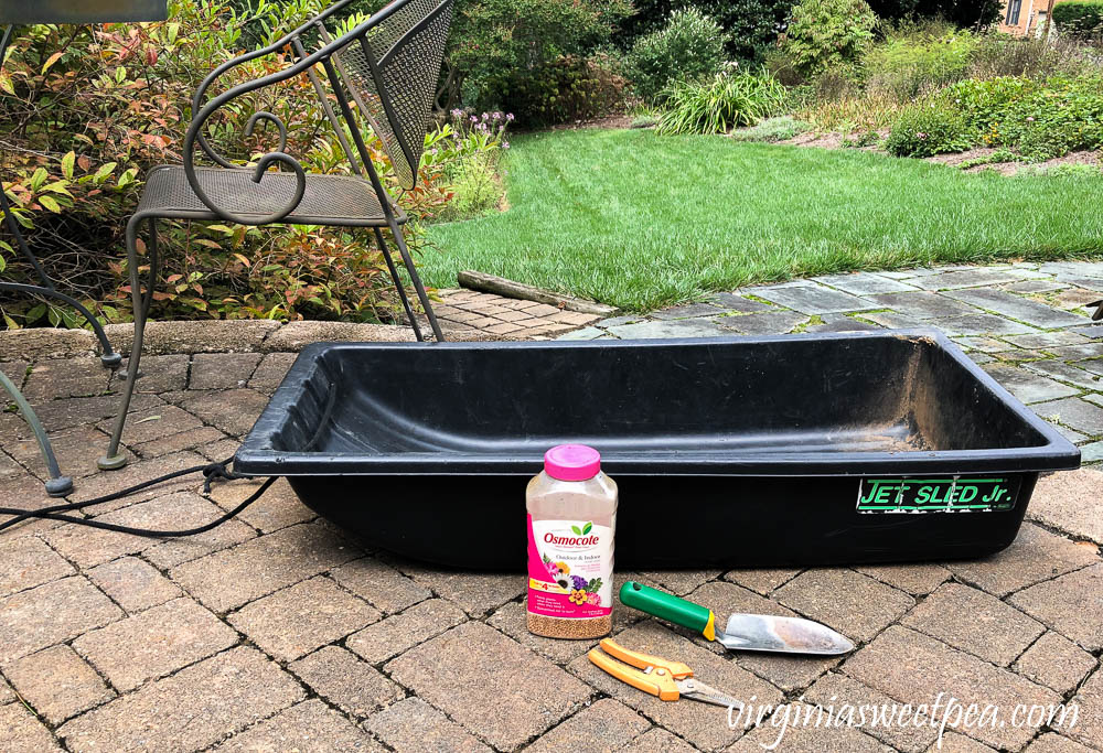 Favorite gardening tools including an ice fishing sled, trowel, clippers, and Osmocote