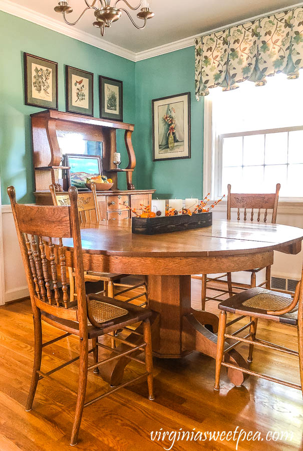 A dining room with antique oak furniture decorated for fall