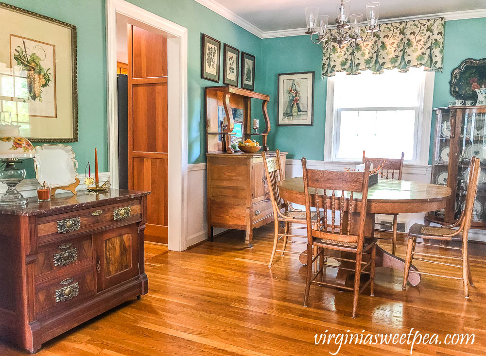 A dining room with antique furniture decorated for fall