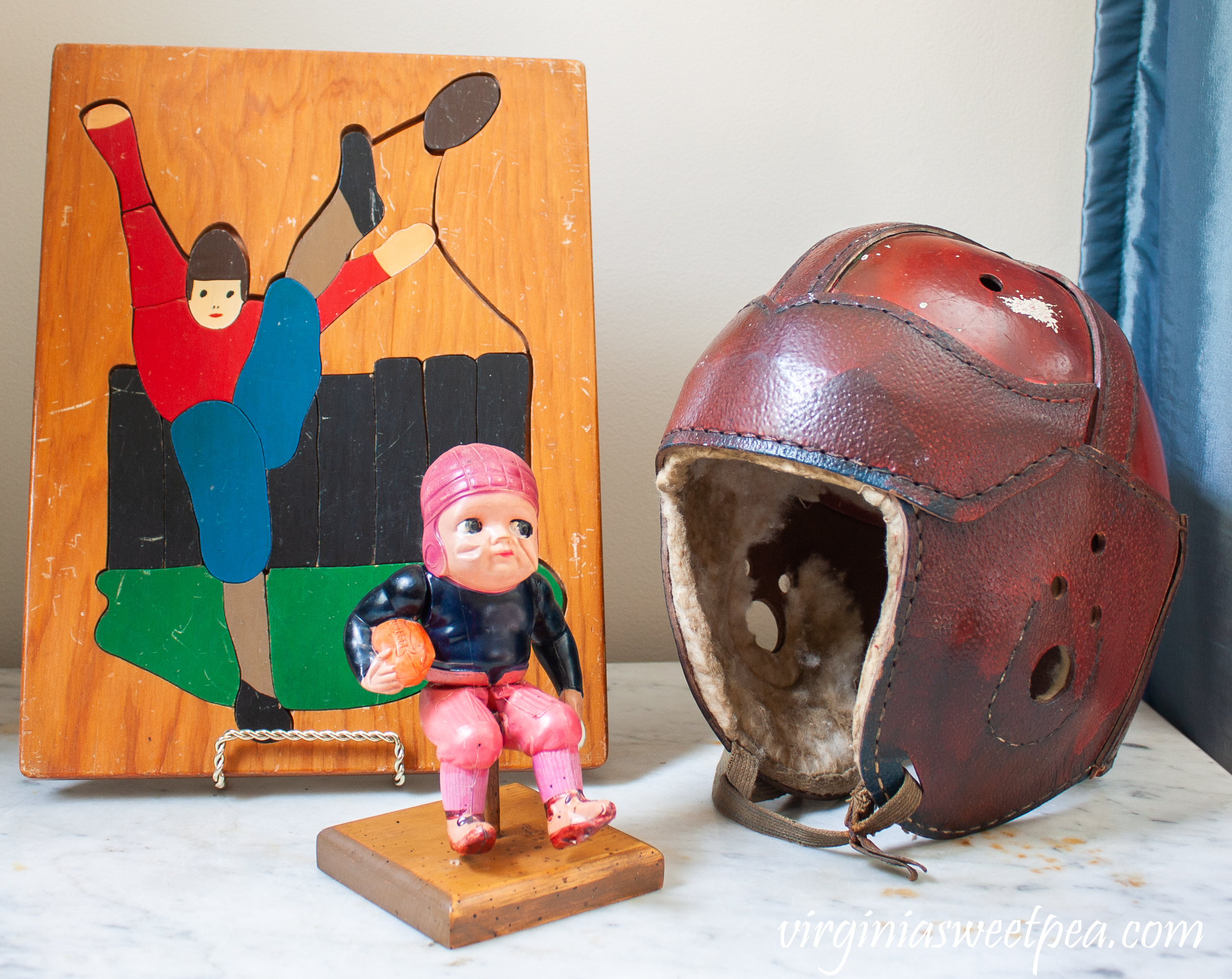 Vintage football vignette with a 1940's football puzzle, 100 year old football toy, and a vintage football helmet