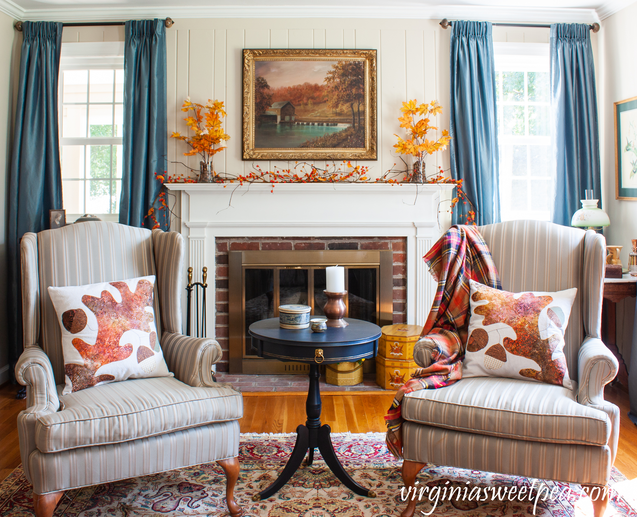 Traditional Fall Mantel - A mantel is decorated for fall with fall foliage anchored in glass vases filled with acorns along with bittersweet, mums, vintage hat boxes, and a vintage painting of a mill in Sussex County, NJ. 